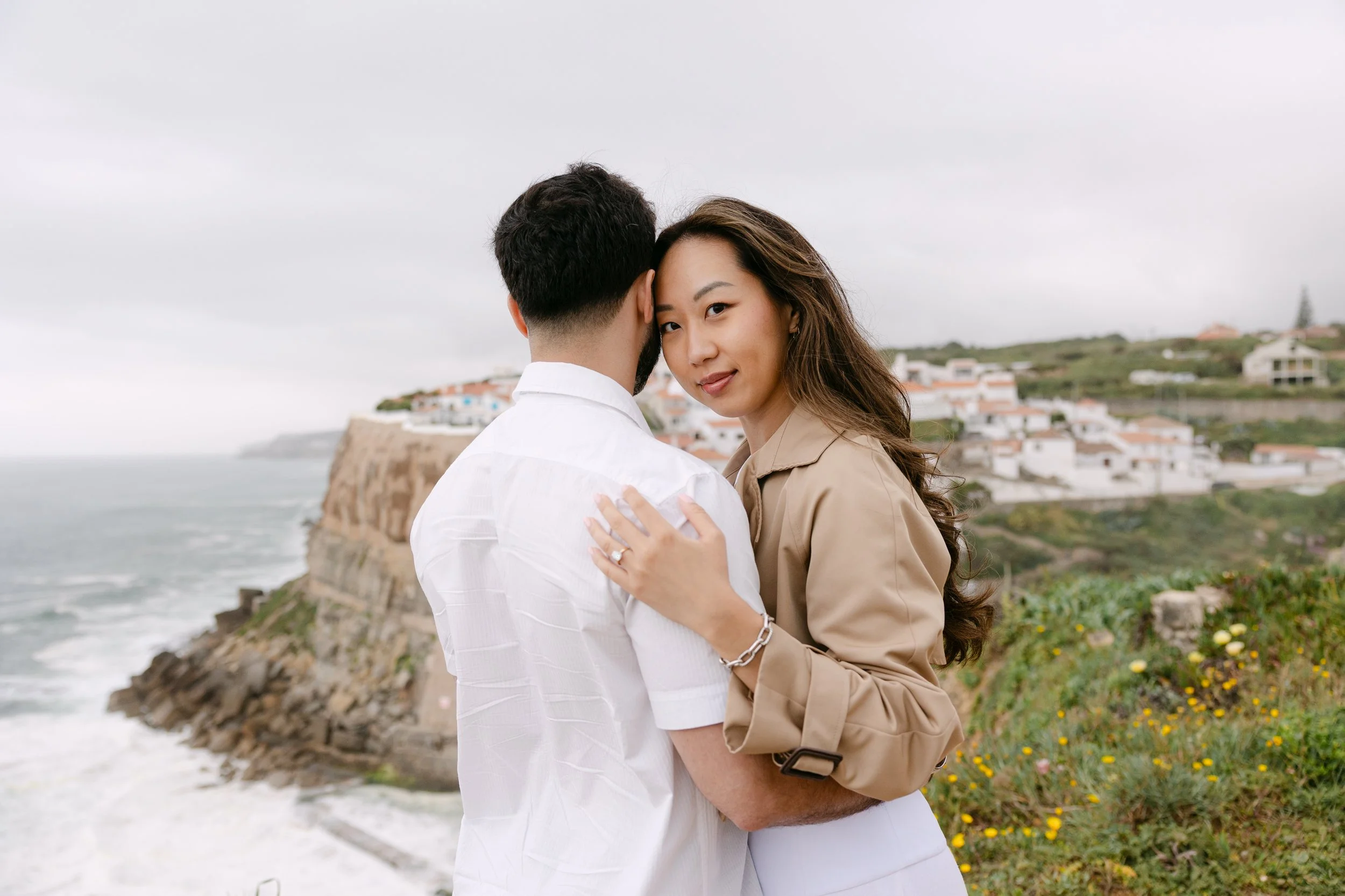 Couple embracing on the cliffs overlooking Azenhas do Mar during romantic Portugal photoshoot.