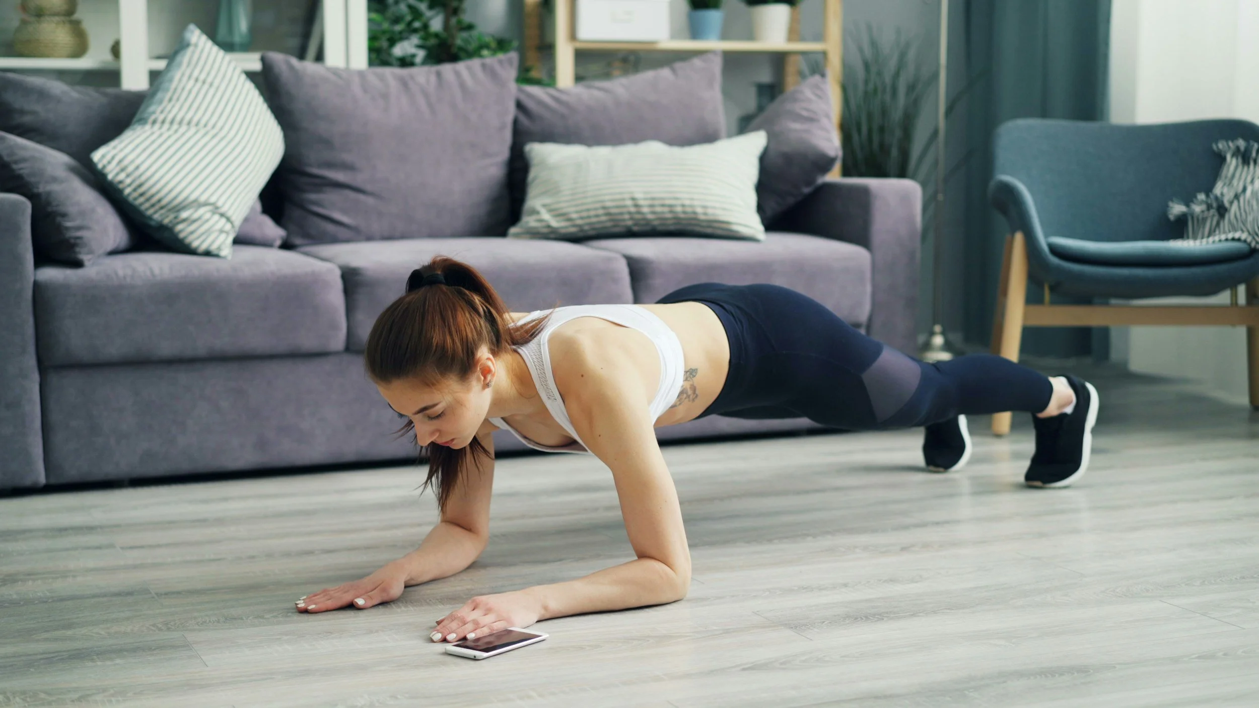 woman doing a plank in her living room