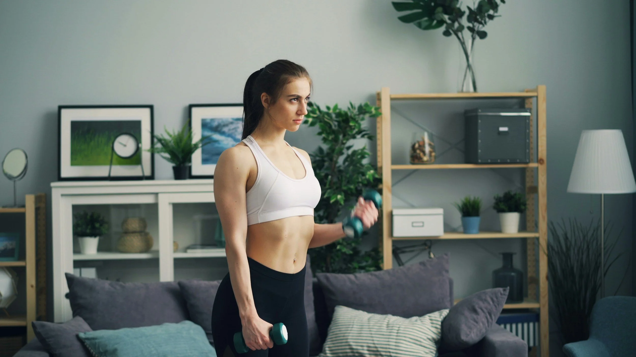 woman doing dumbbell curls in her living room
