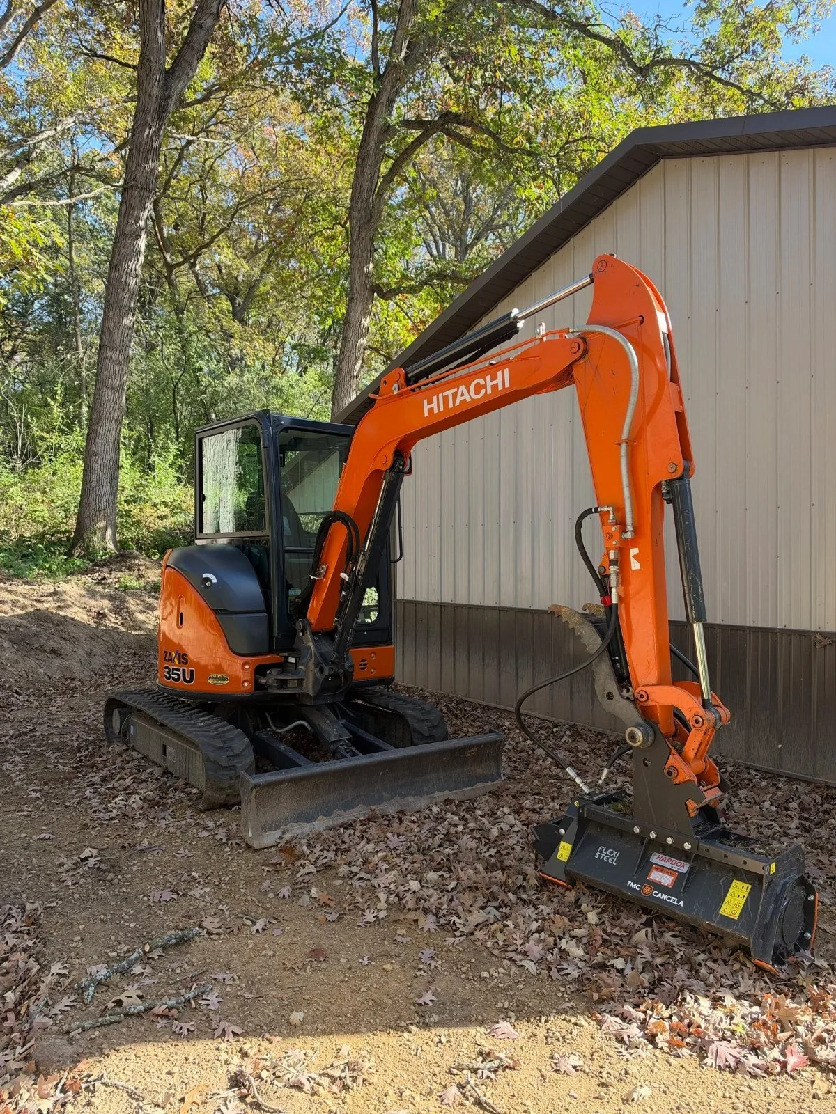 Hitachi mini excavator with a forestry mulching head ready for a land clearing job