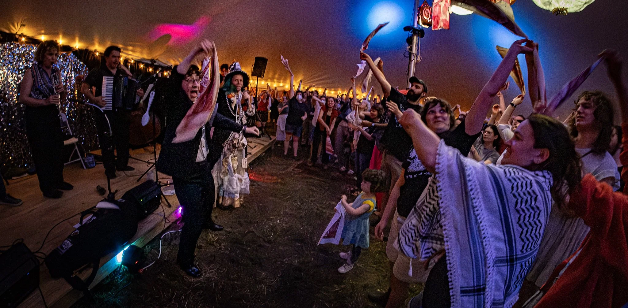 People toss their handkerchiefs in the air during the landsmanshaft mutual aid banquet at KlezCummington 2025.
