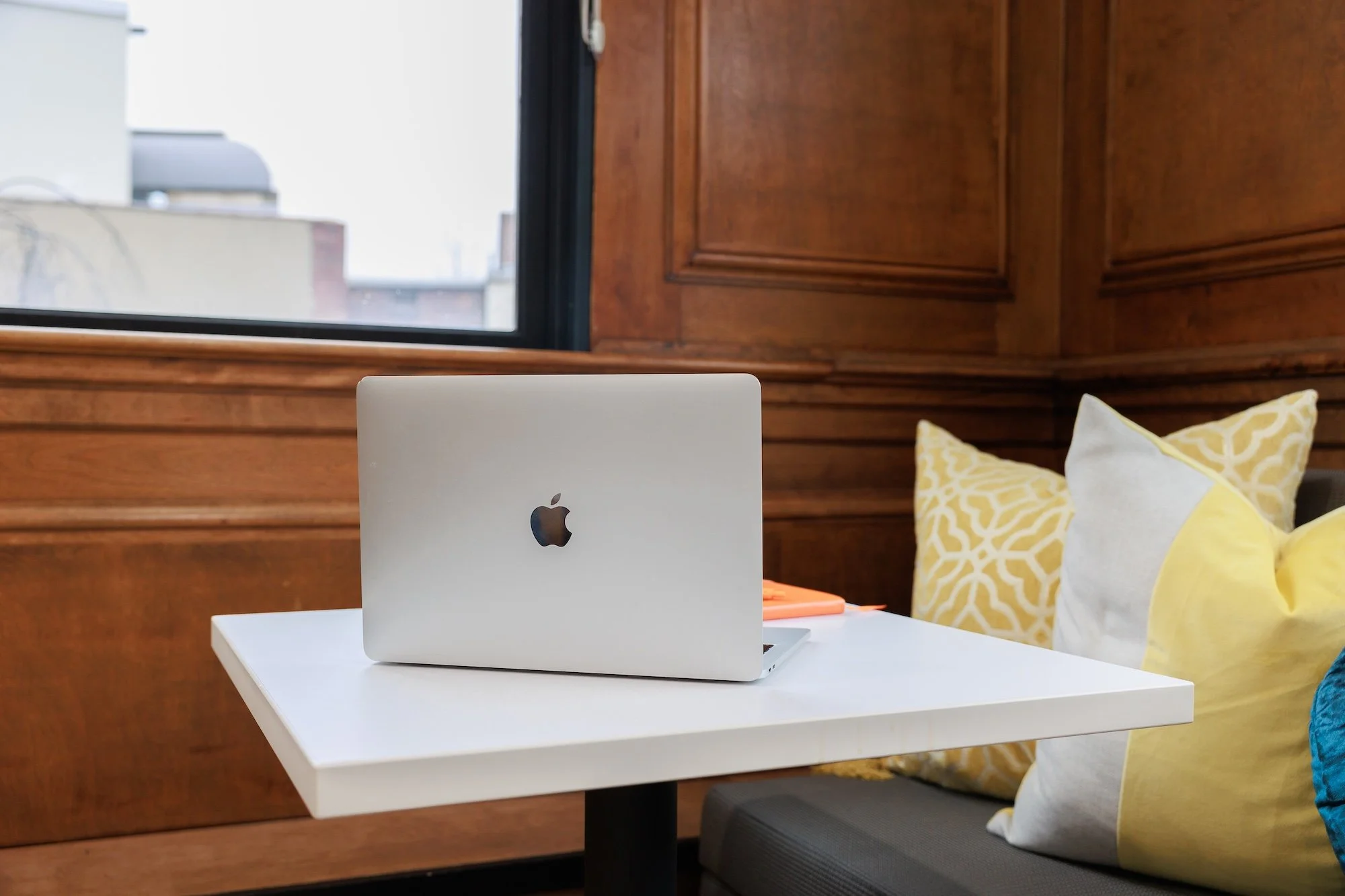 Laptop on a white table in a wood paneled office