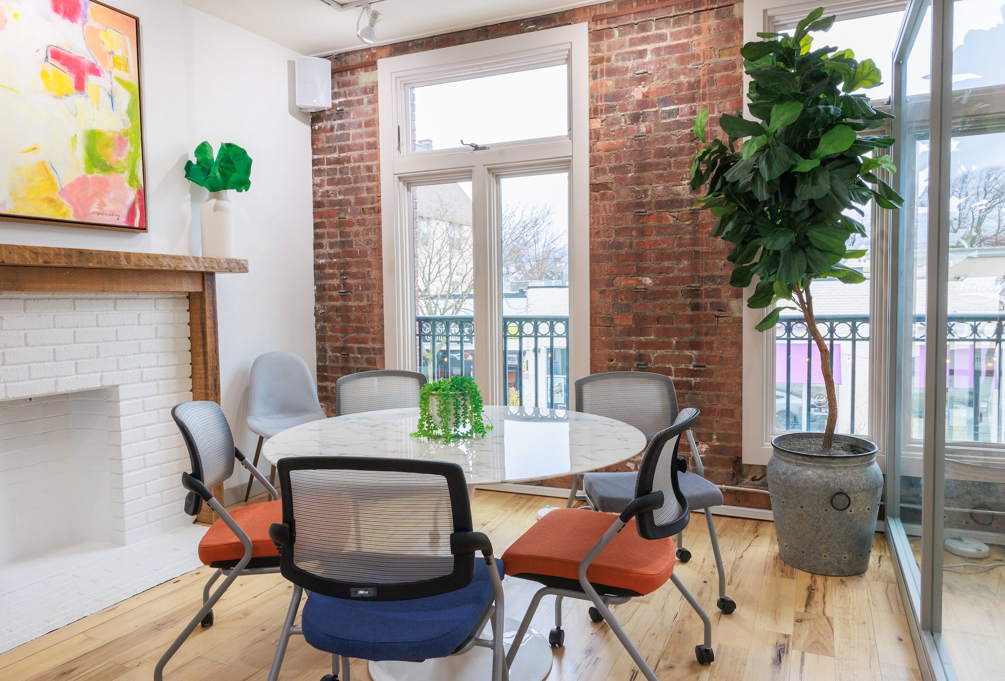 Small conference room with a white table and exposed brick walls