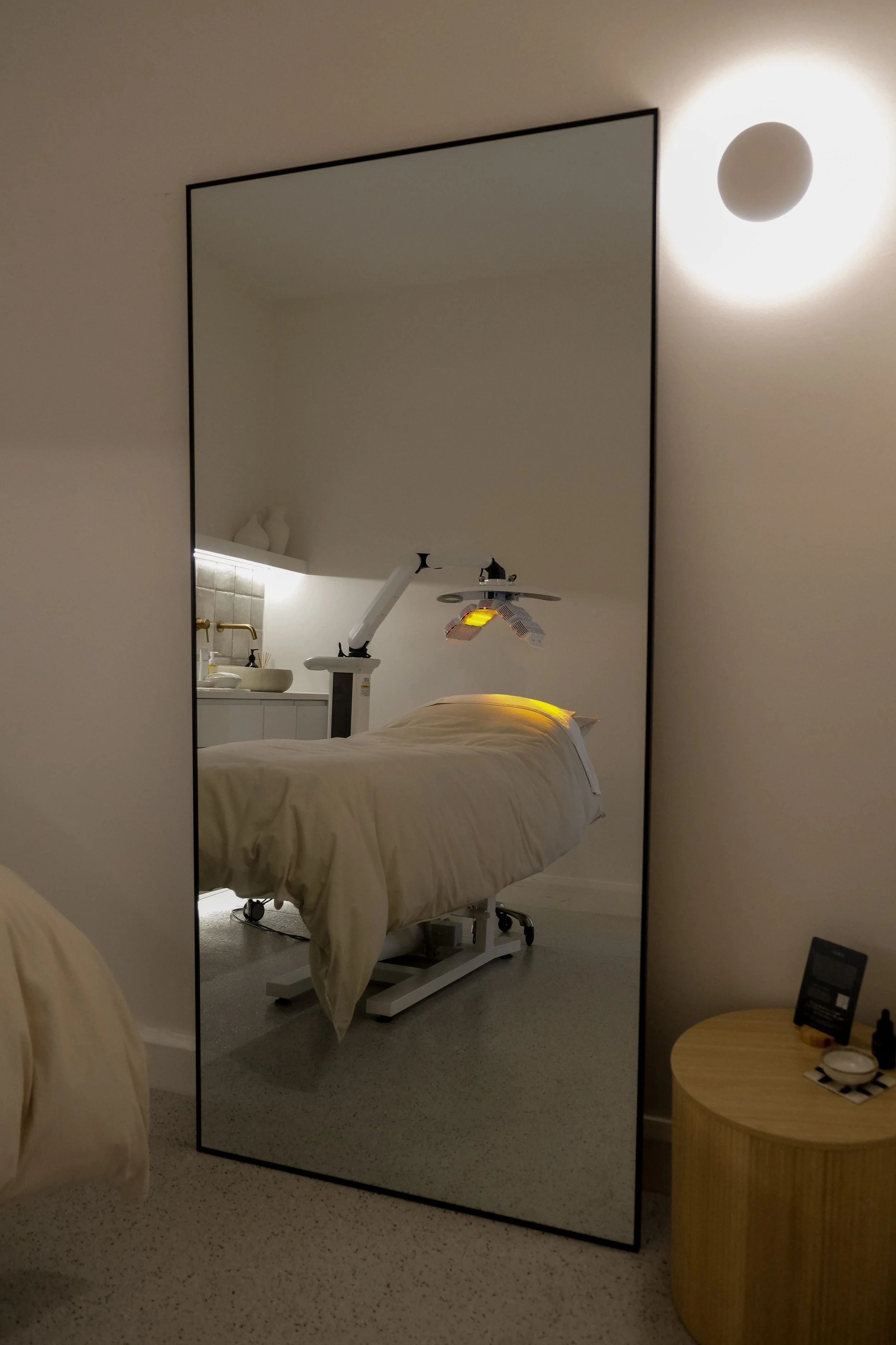 Treatment room with LED light therapy panel over a treatment bed at Saltt Burleigh Heads