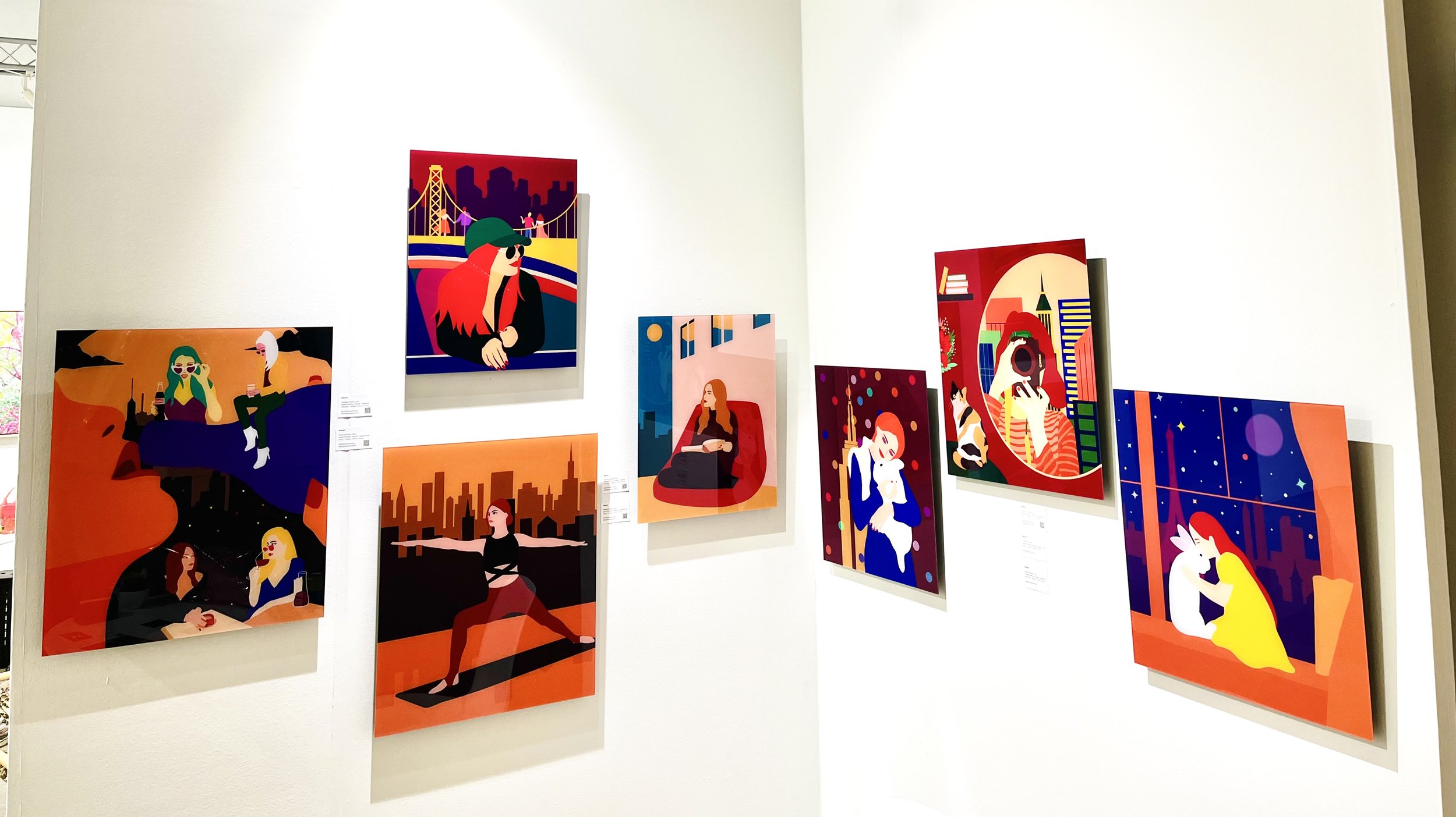 Art gallery wall displaying colorful, modern paintings of people in various settings, featuring urban landscapes and abstract backgrounds.