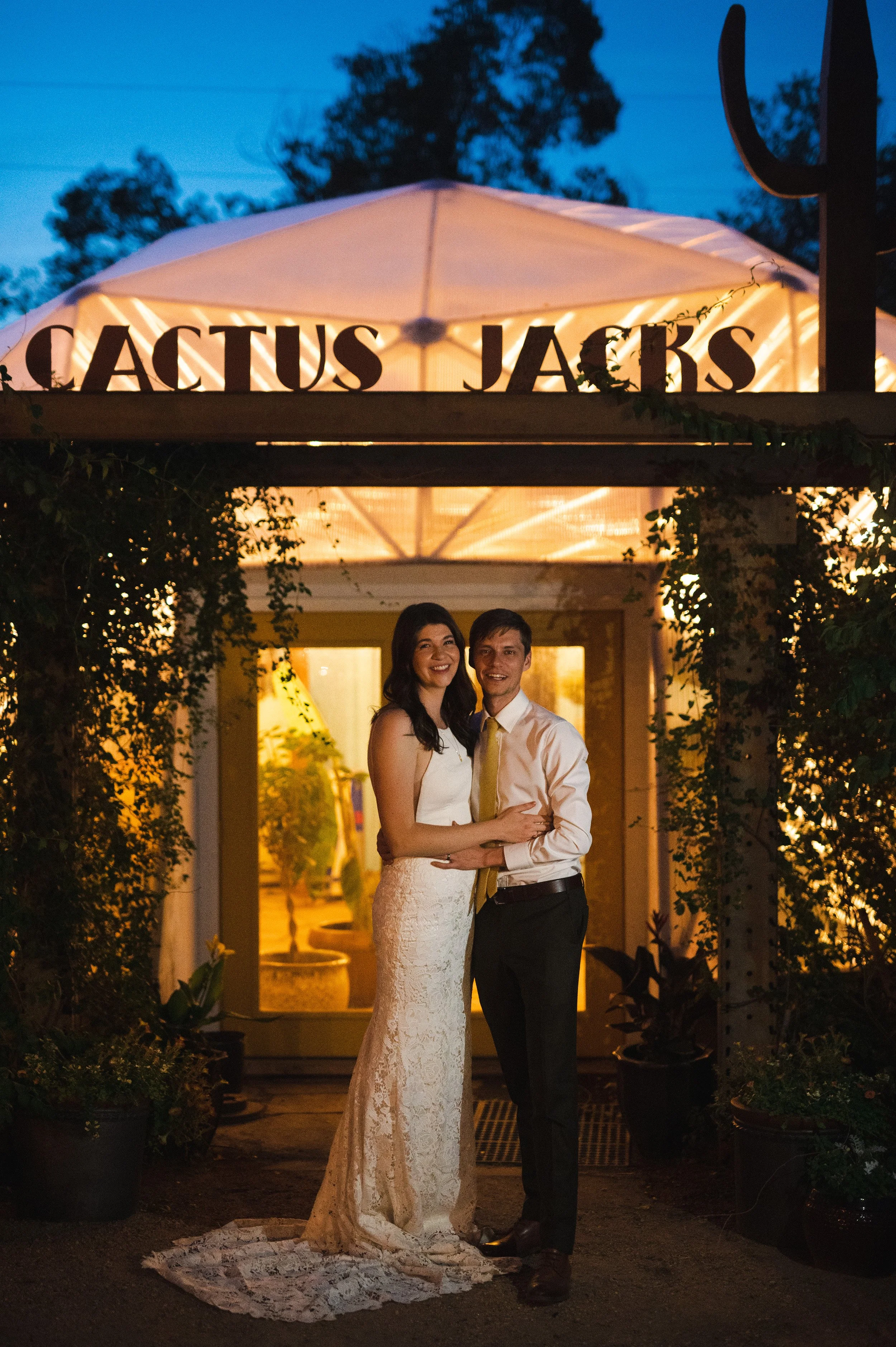 Couple standing in front of Cactus Jacks entrance at night