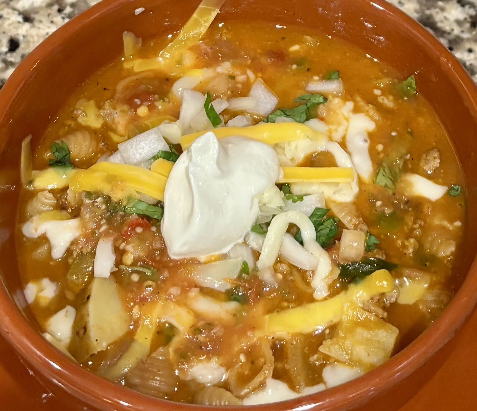This is classic Mexican soup dish with pasta shells, ground beef, tomatoes, potato, and peppers. Garnish with sour cream, cheese, and cilantro if desired