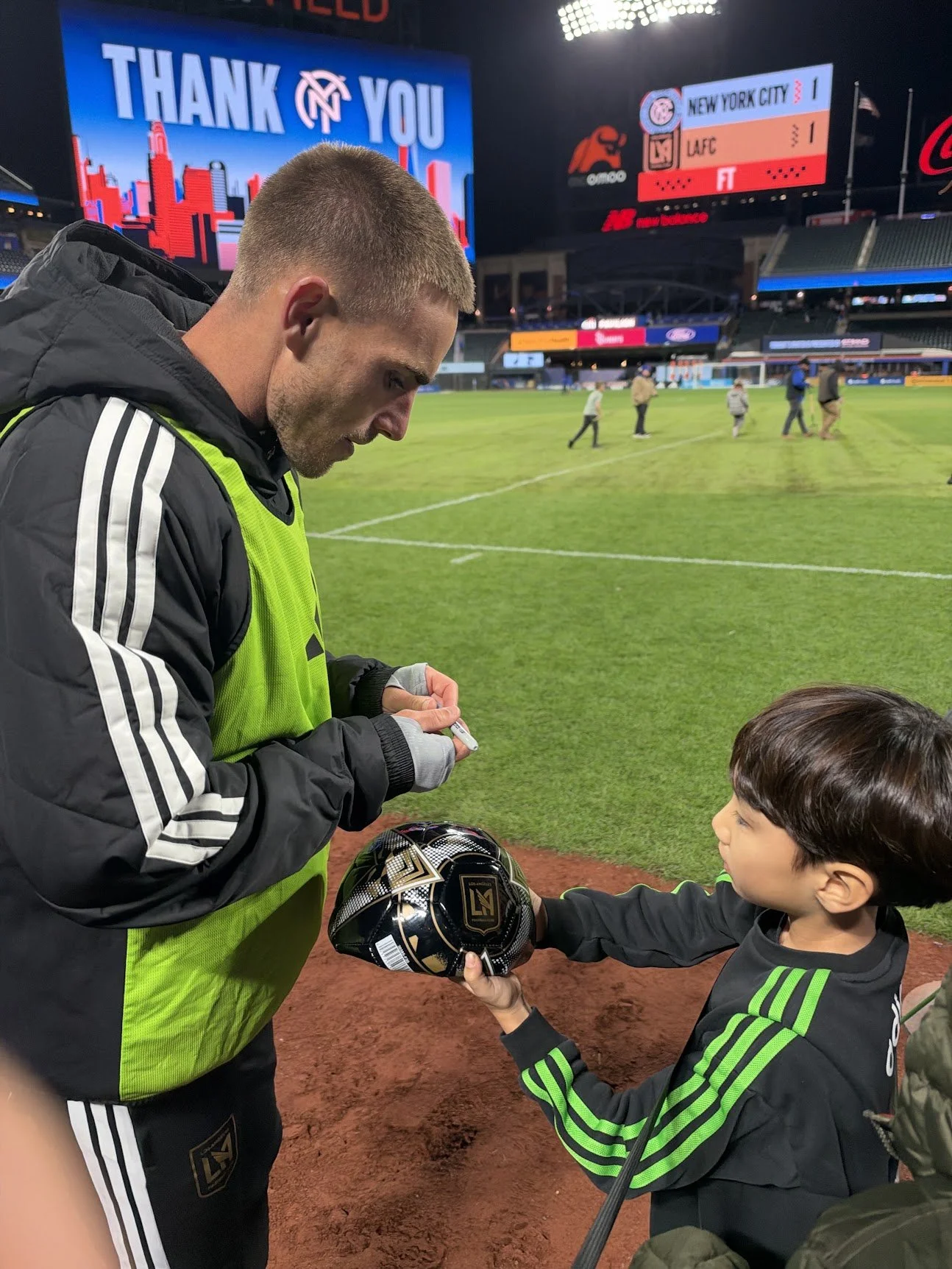 LAFC's Tyler Boyd signing a boy's ball after NYCFC vs. LAFC ended 1–1