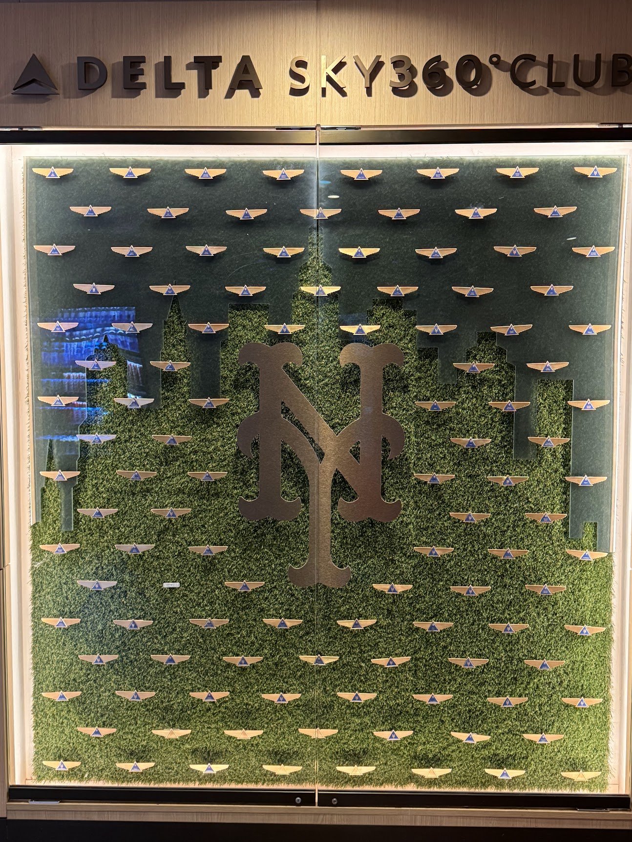 Delta pilot wings arranged into the New York skyline around the Mets logo inside the Delta Sky360 Club at Citi Field