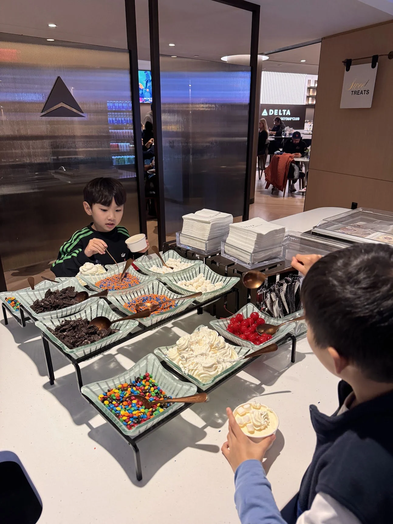 Kids building sundaes at the dessert bar in the Delta Sky360 Club at Citi Field