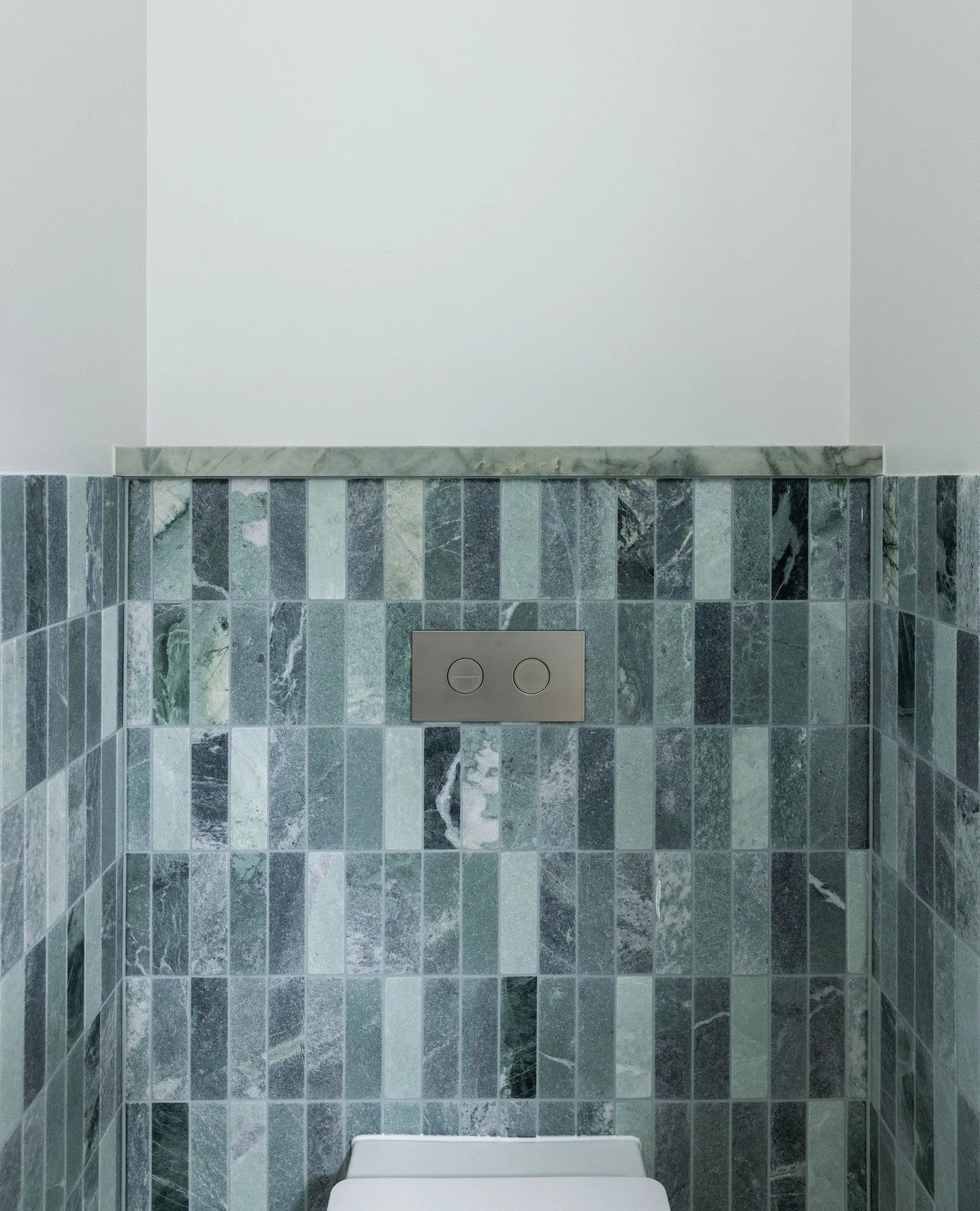At Home McRaes, every design decision had purpose.⁠
⁠
In the powder room, the wall needed to be built out to house the concealed toilet cistern. Rather than hide this necessity, we used it as an opportunity, cladding the projection in stone that cont