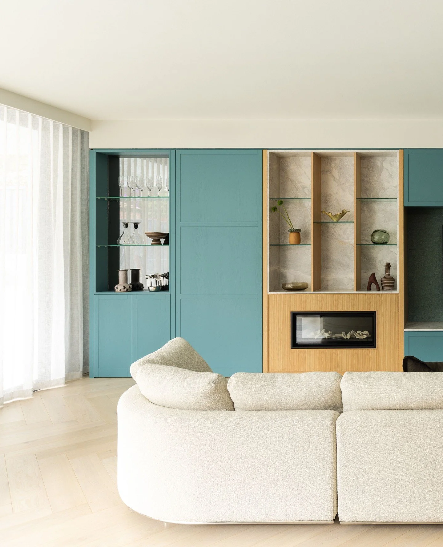 Design is at its best when it supports the way you live.⁠
⁠
This living space is layered with intention: a curved sofa that invites conversation, a custom bar that blends function with elegance, and cabinetry that celebrates both display and storage.