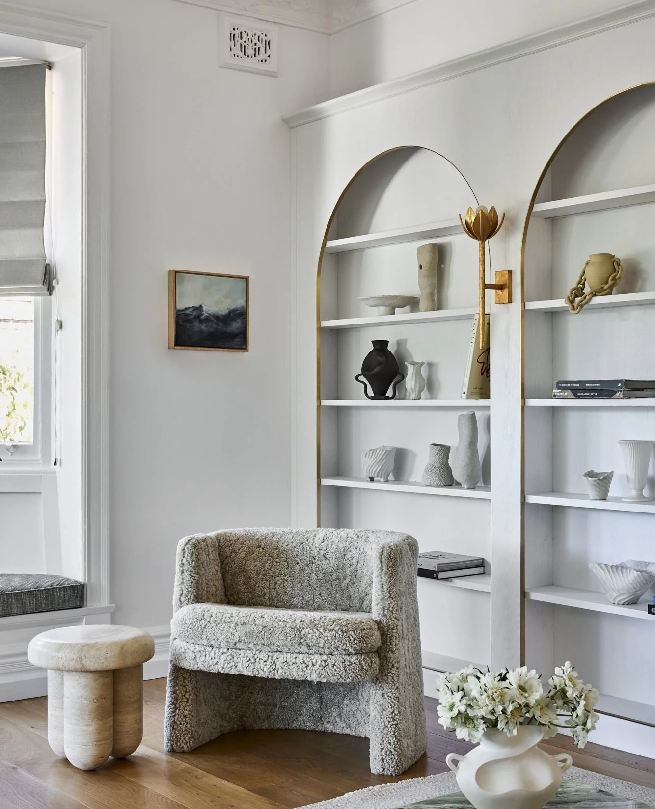 We designed this living space to be anchored by sculptural forms, soft furnishings that invite pause, reclaimed timber floors that ground the palette, and arched shelves framed in brass for a touch of quiet glamour.
Every element works in harmony