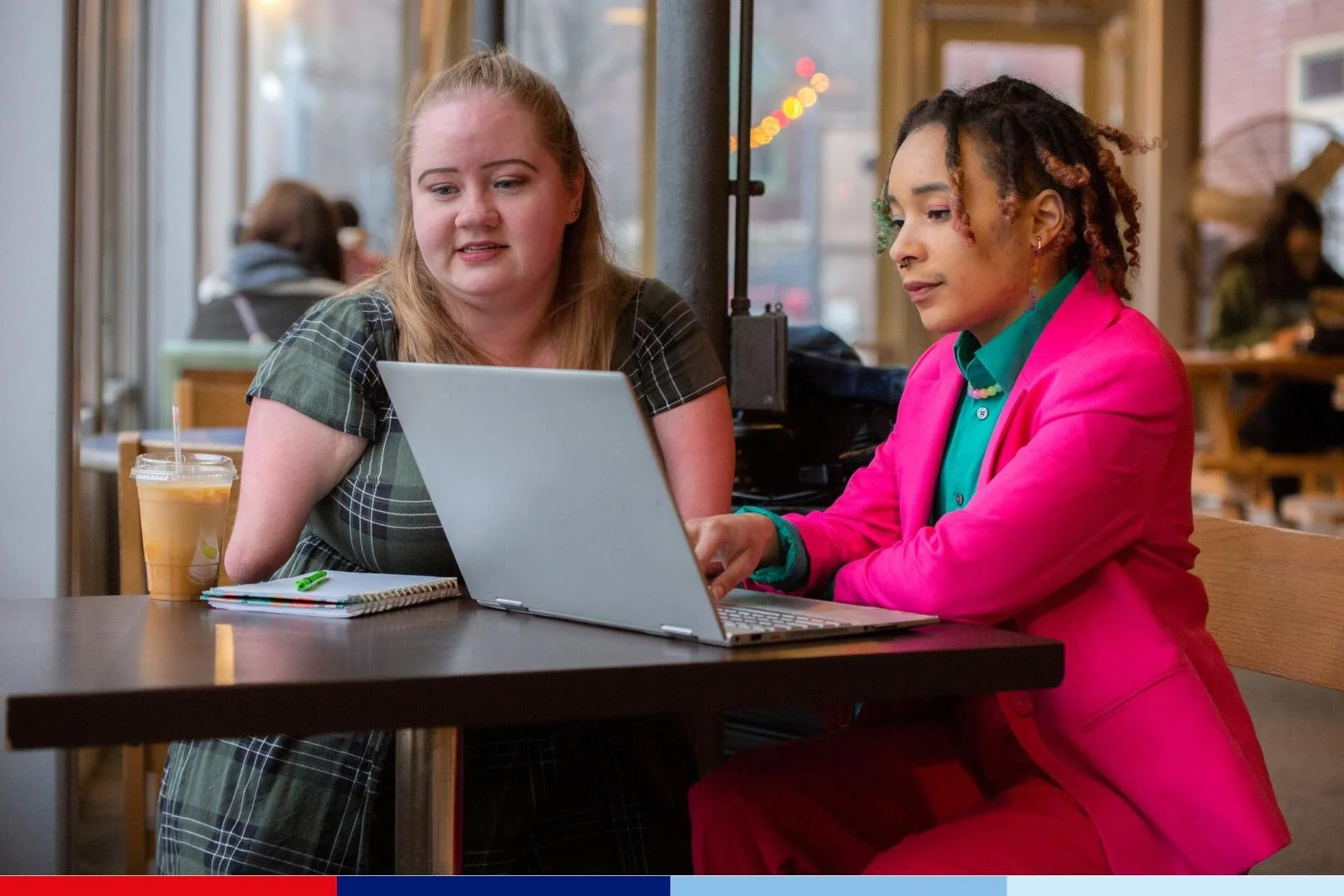 Two individuals sitting at a table with a laptop