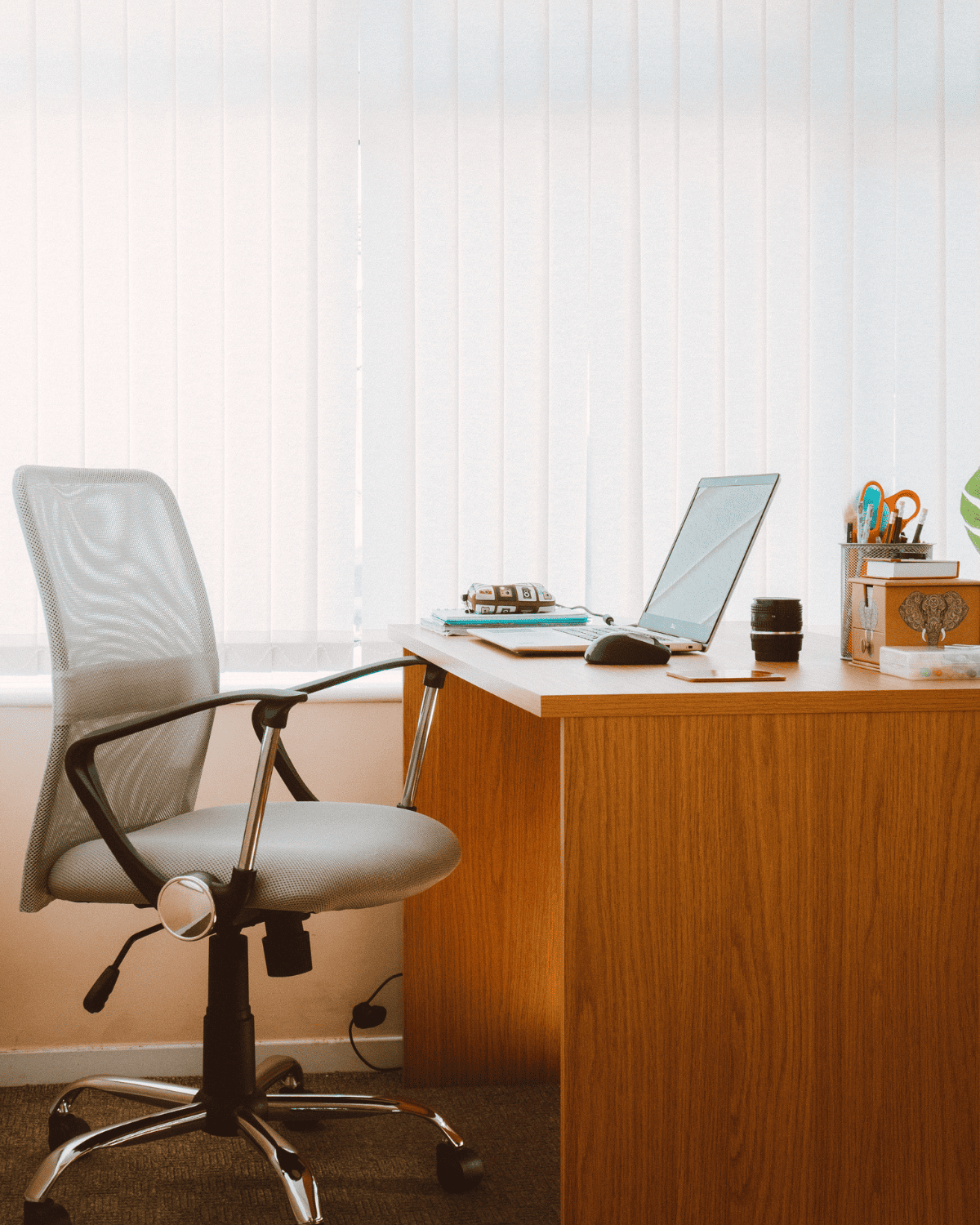 A modern office desk with a laptop, notepad, and stationery, representing a virtual assistant getting ready to work on tasks that align with your goals and needs.