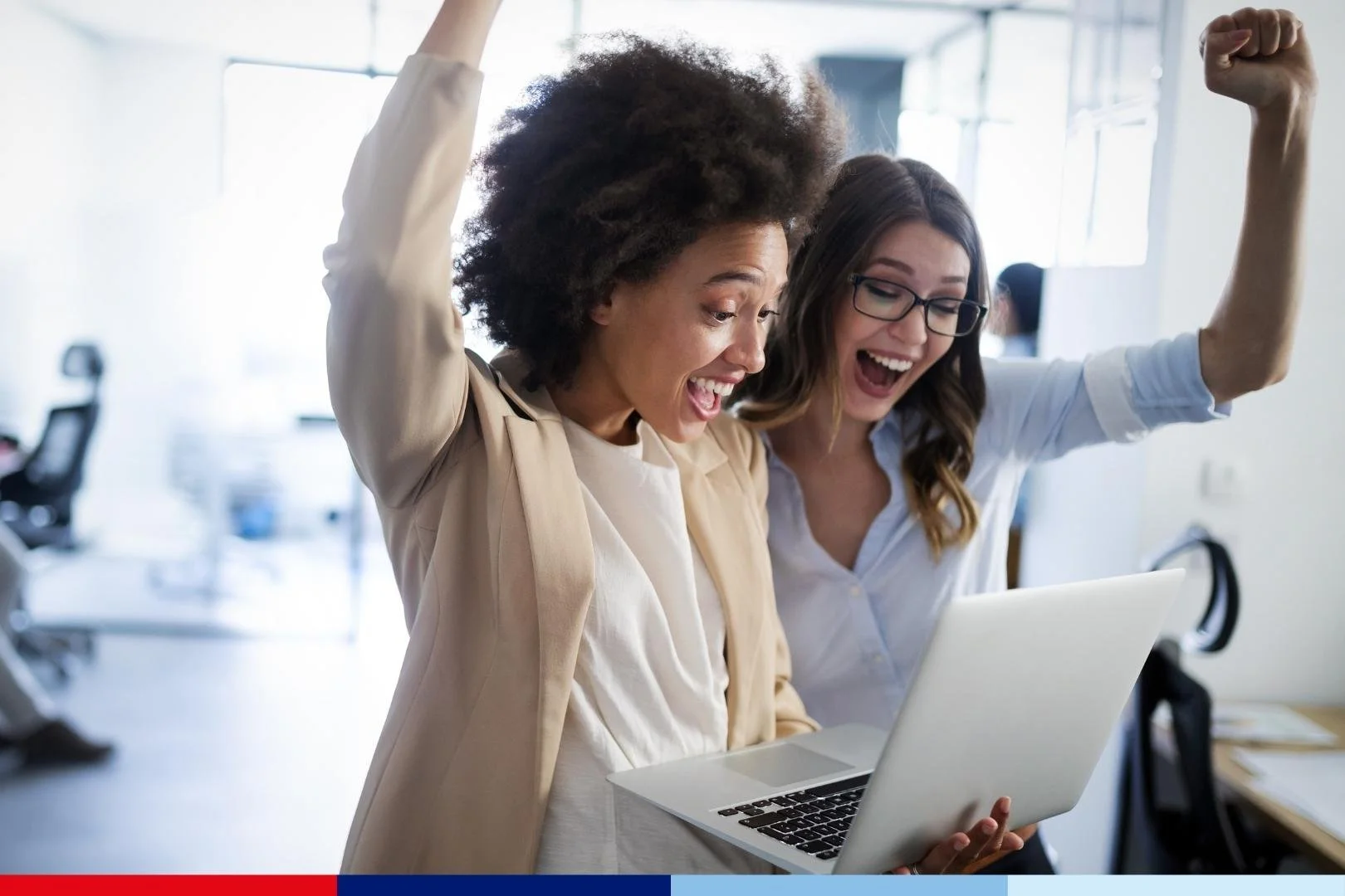Two people celebrating with a laptop in an office