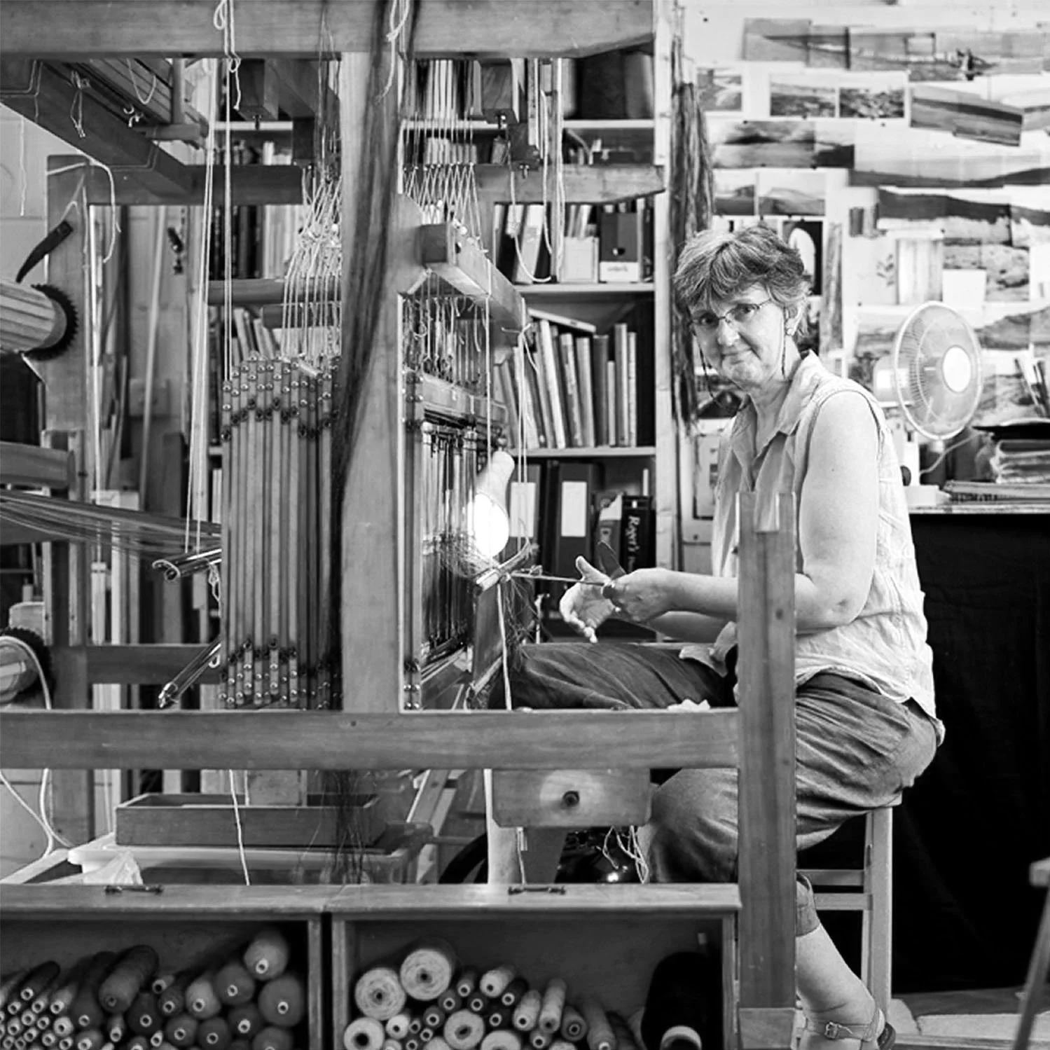 Textile artist working attentively at her wooden loom, weaving colorful threads into fabric
