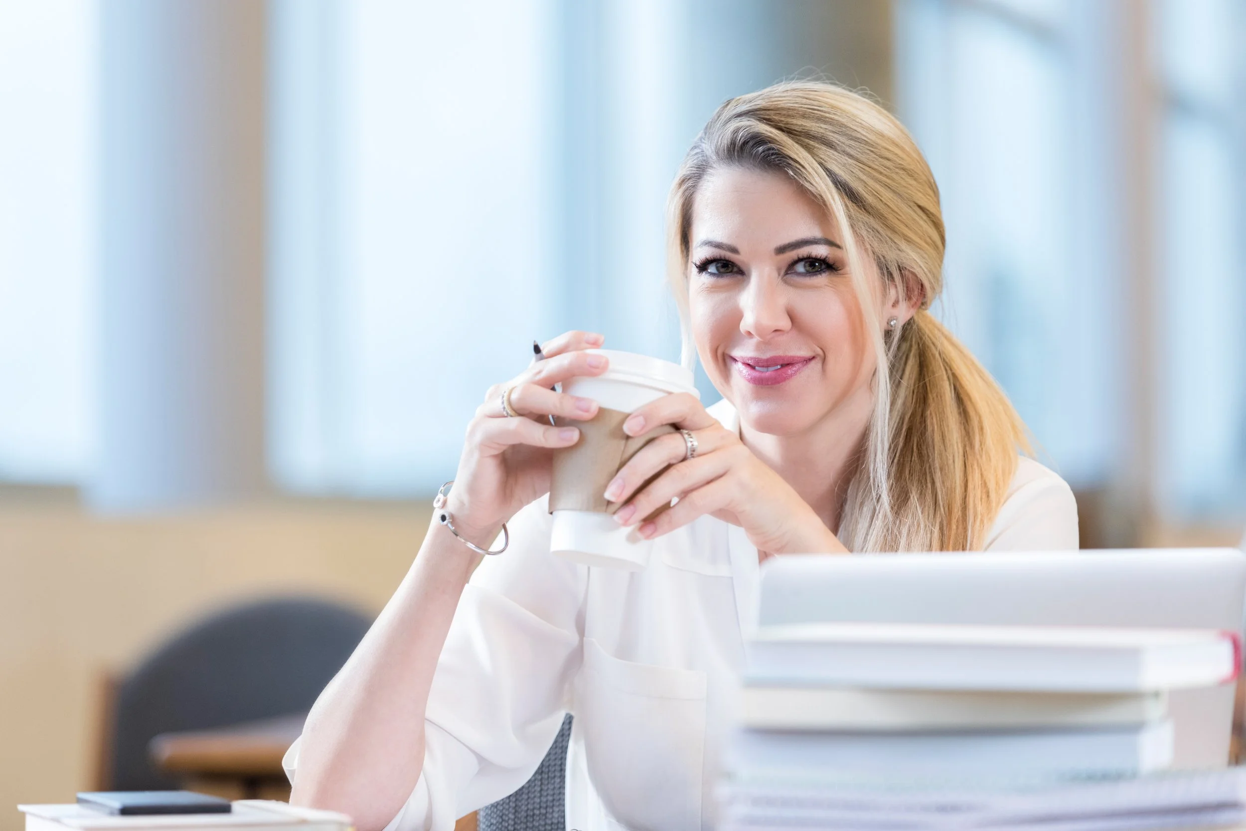 iStock-Blonde female with coffe and a smile at her computer_911250148.jpg