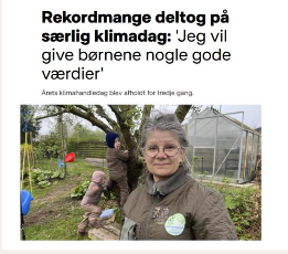 Kvinde i foran, udenfor med drivhus i baggrunden, deltager i klimadagsbegivenhed
