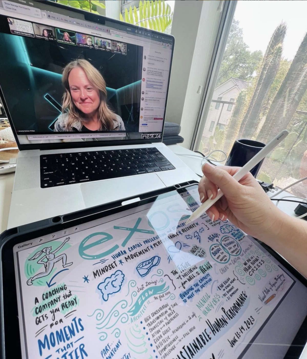 A person is taking notes with a stylus on a digital tablet while participating in a virtual meeting on a laptop. The tablet displays colorful handwriting and doodles about human capacity, mindset, flow, and performance. The laptop shows a video call 