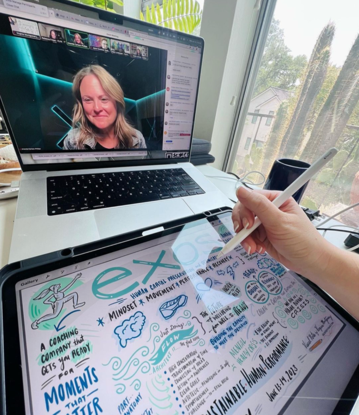 A person holding a stylus and taking notes on a tablet with a colorful infographic about human performance, mindset, and resilience. On a laptop in the background, a video call with several participants is visible.