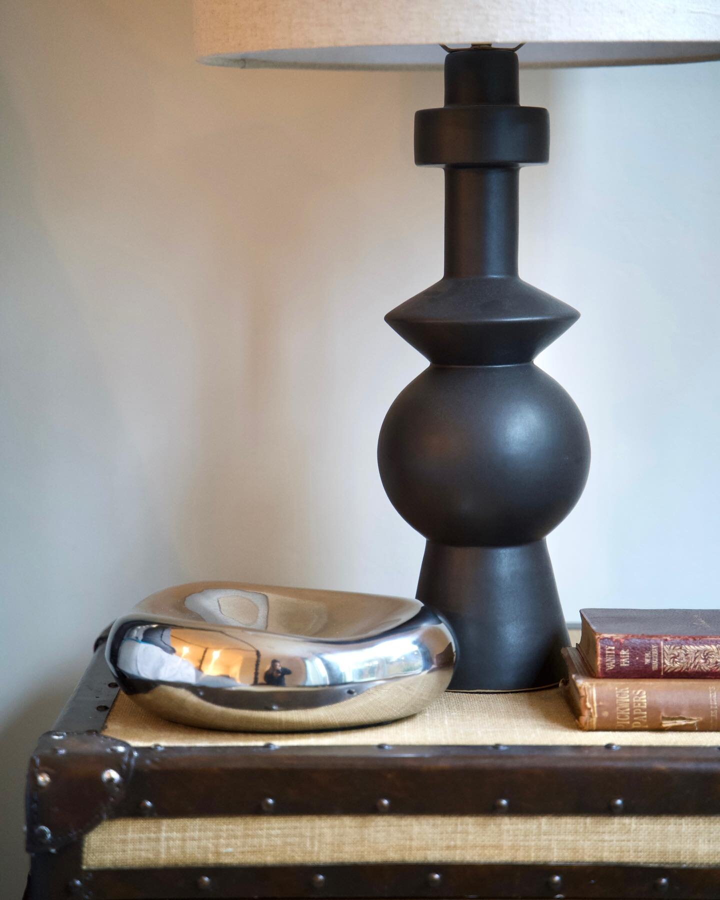 Mixing past and present, old and new, dark and light always adds some「 f l a v o r 」

We brought this classic burlap trunk nightstand into modern day by adding a totem table lamp and chrome dish for accessories. The vintage books are from the clients