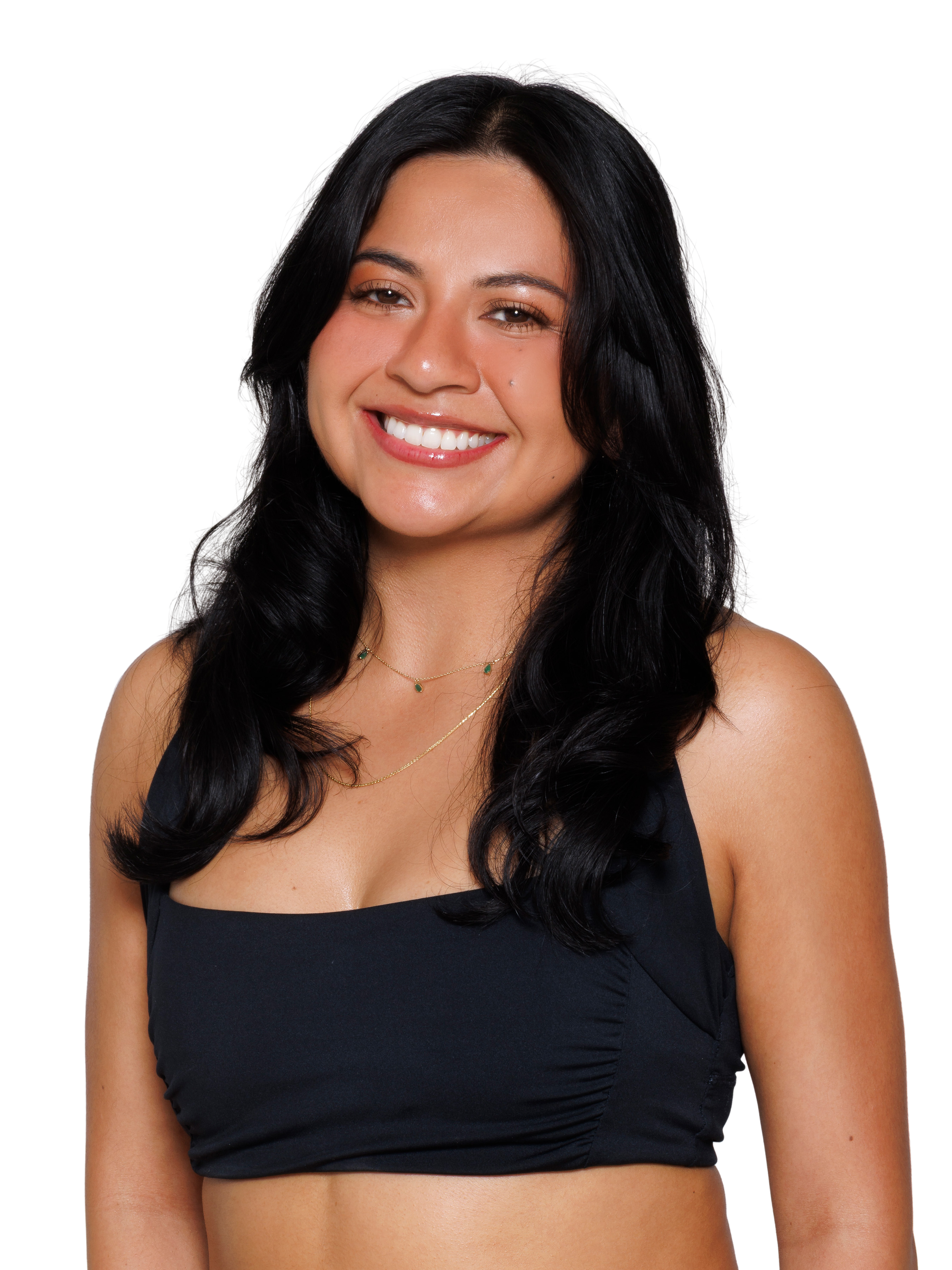 A woman smiling at the camera with curled black hair, wearing a black square-cut sports bra