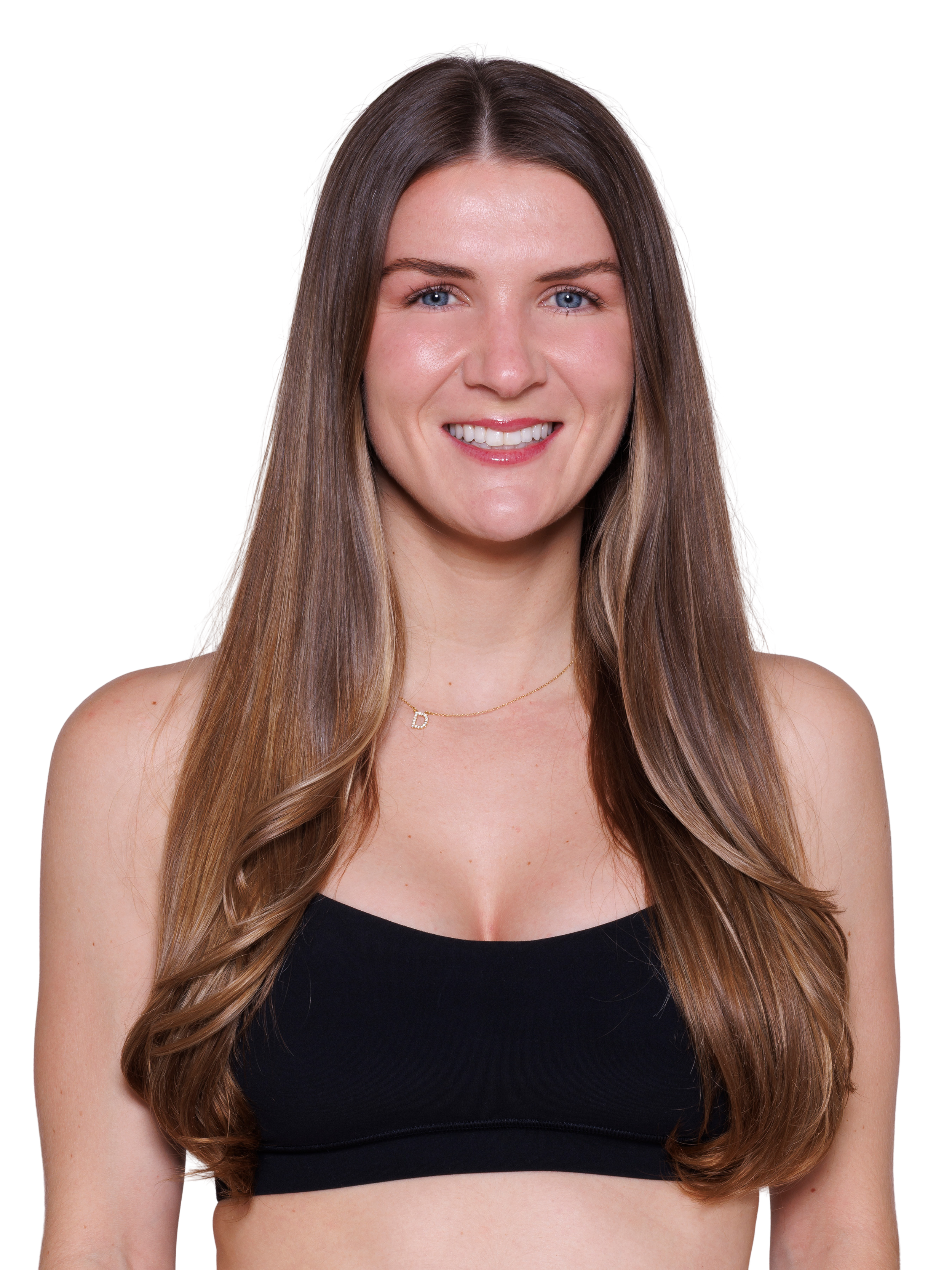 A smiling woman with long brown hair wearing a black sports bra.