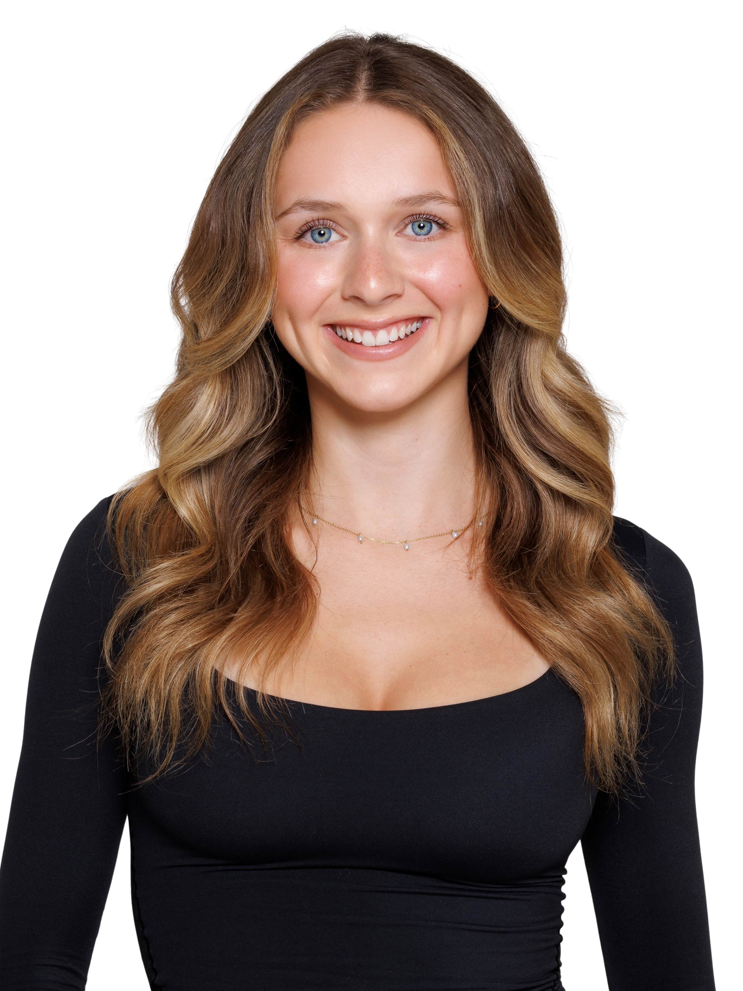 A young woman with long wavy blonde hair, wearing a black sports crop top, smiling at the camera.