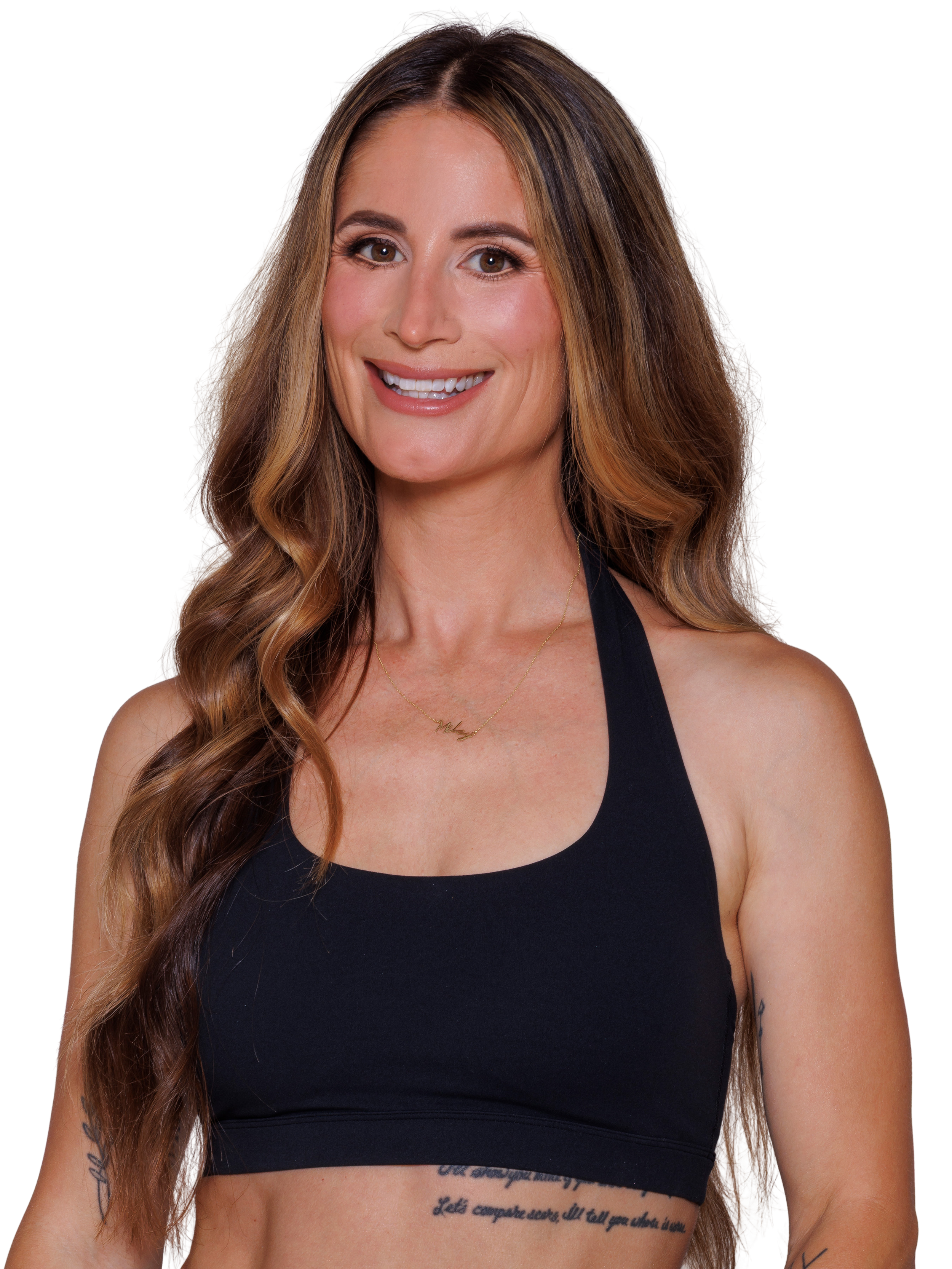 A woman with blonde hair smiling, wearing a black sleeveless crop top and a gold chain necklace, white background.