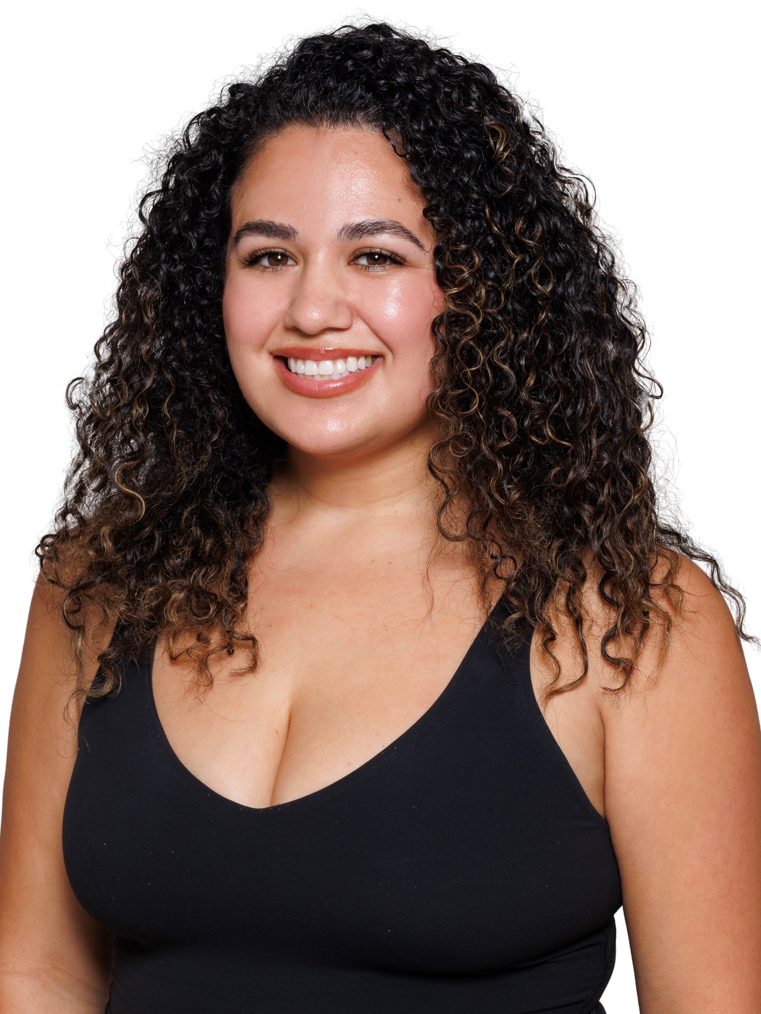 A woman with very curly dark brown hair and a black V-cut sleeveless top, smiling at the camera.