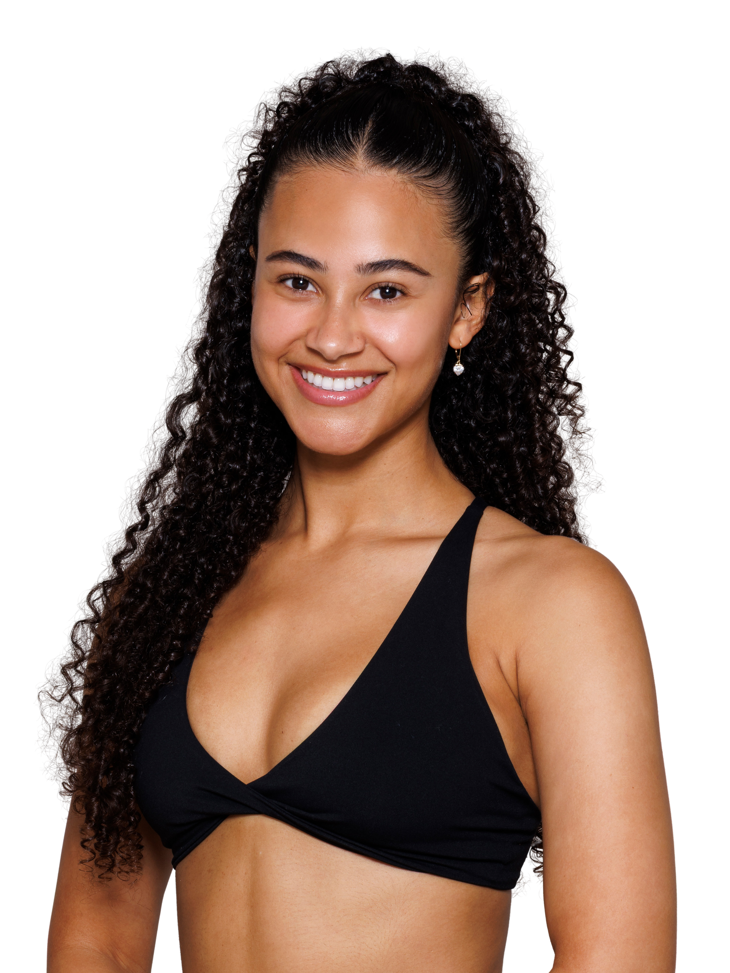 A young woman with long black curly hair, smiling, wearing a black sports bra, against a white background