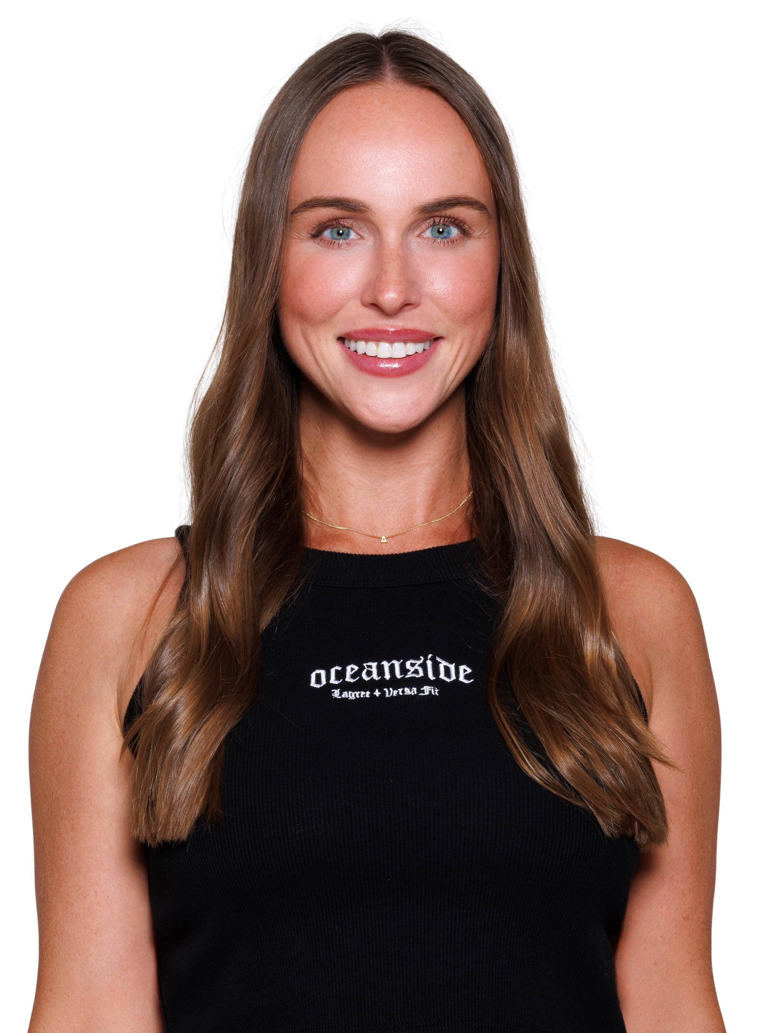 Portrait of a young woman with long brown hair, smiling, wearing a black sleeveless crop top, with accessories including small earrings, a necklace, and a bracelet, posing against a plain white background.