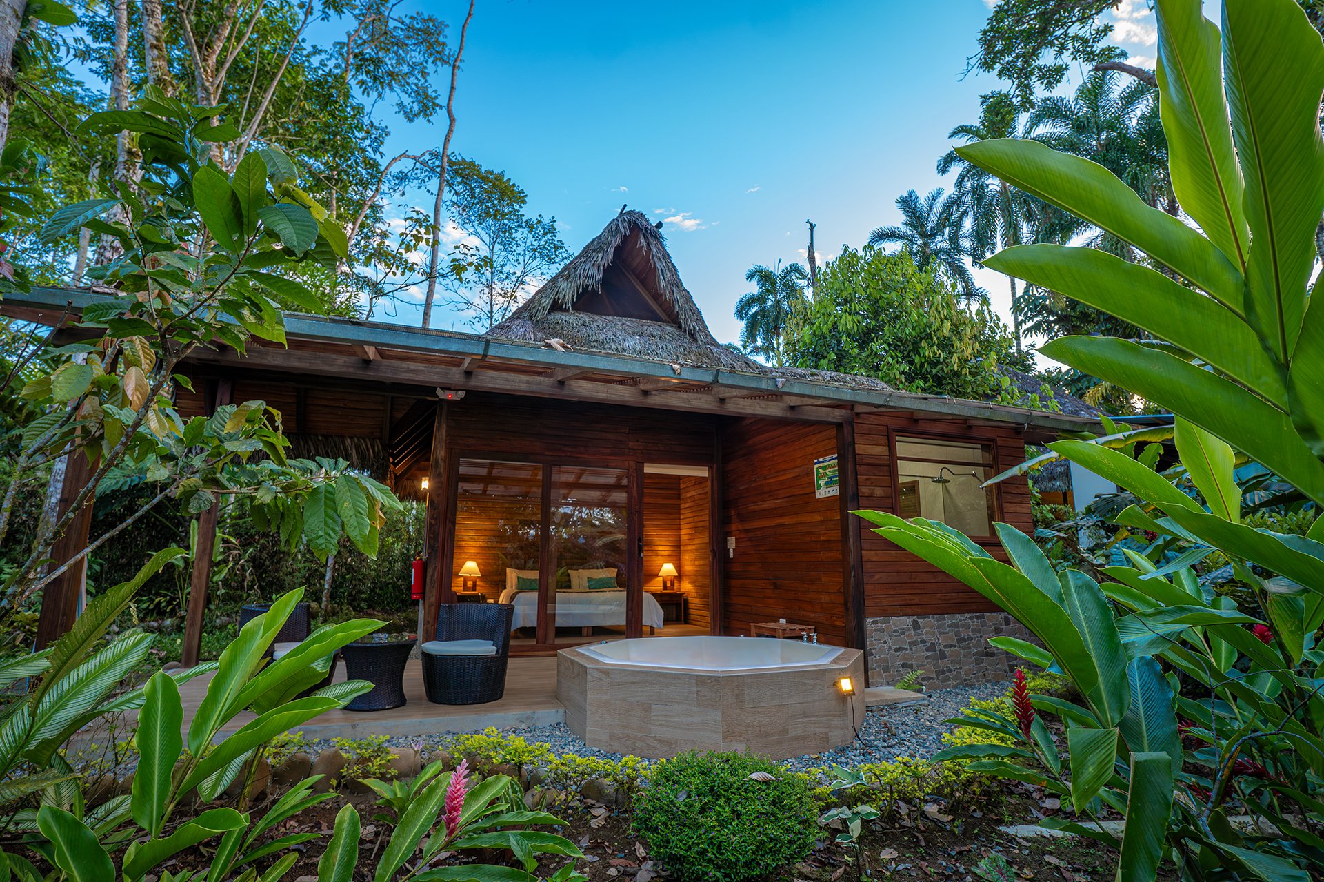 Exterior de cabaña con jacuzzi al atardecer