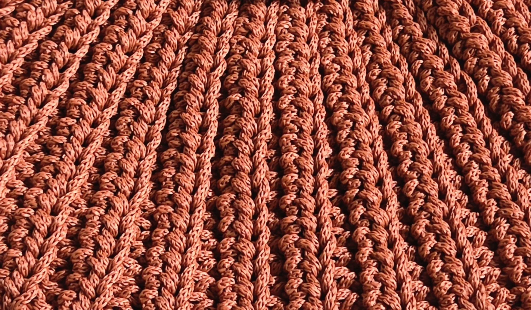 Close-up of multiple orange ropes woven together in a pattern.
