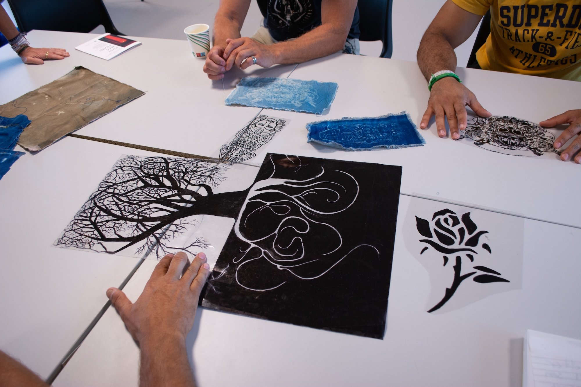 Sceneteppe til Ringerike fengsel, avdeling Ullersmo, i samarbeid med en gruppe innsatte. Teknikk og materiale: Cyanotype på tekstilbiter i bomull, lin, silke og ull, broderi i ull, silke og bomull, applikert på kraftig bomullstekstil. Håndsøm. Fôret 