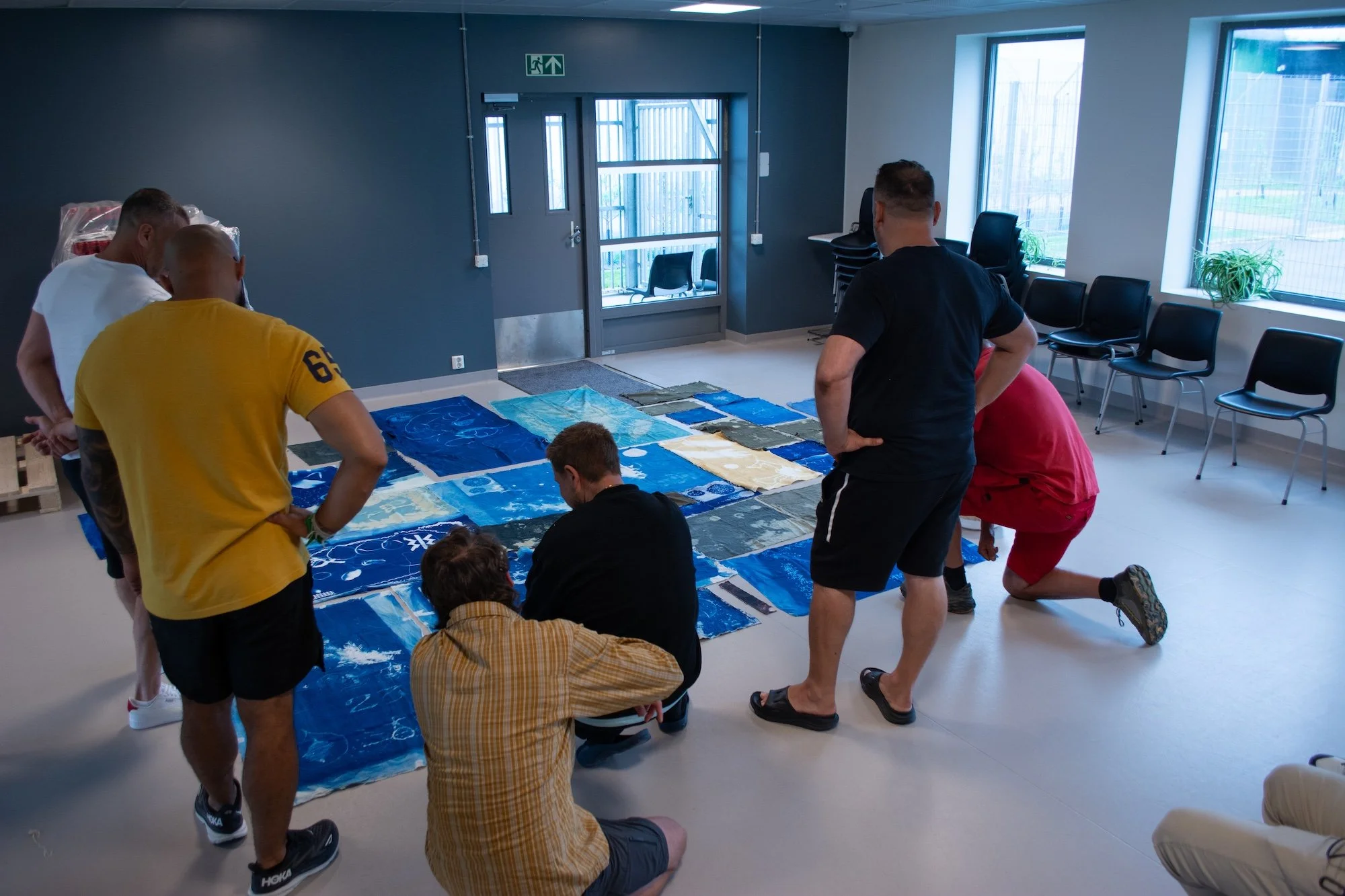 Sceneteppe til Ringerike fengsel, avdeling Ullersmo, i samarbeid med en gruppe innsatte. Teknikk og materiale: Cyanotype på tekstilbiter i bomull, lin, silke og ull, broderi i ull, silke og bomull, applikert på kraftig bomullstekstil. Håndsøm. Fôret 