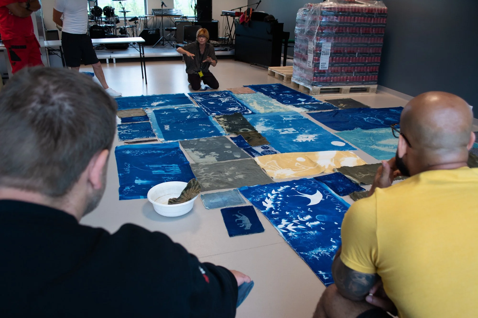 Sceneteppe til Ringerike fengsel, avdeling Ullersmo, i samarbeid med en gruppe innsatte. Teknikk og materiale: Cyanotype på tekstilbiter i bomull, lin, silke og ull, broderi i ull, silke og bomull, applikert på kraftig bomullstekstil. Håndsøm. Fôret 