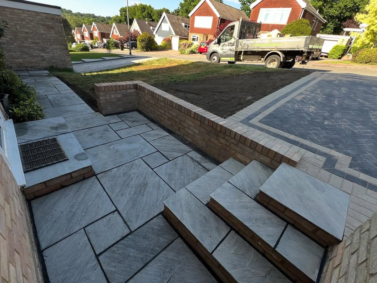 We have transformed the original driveway and porch, previously a standard concrete base with a 1960s design, into a modern, aesthetically pleasing space with a softer, more appealing appearance. The redesign has increased parking capacity and reduce