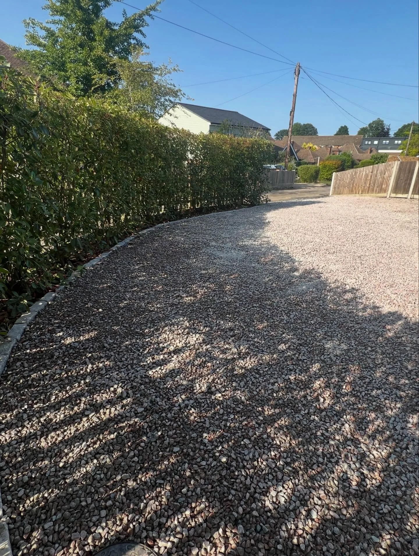 For this project, the client wished to create a larger parking area. We achieved this by removing the existing hedge and excavating the old, unused front lawn. The area was finished with a blend of silver and red 20mm granite chippings to complement 