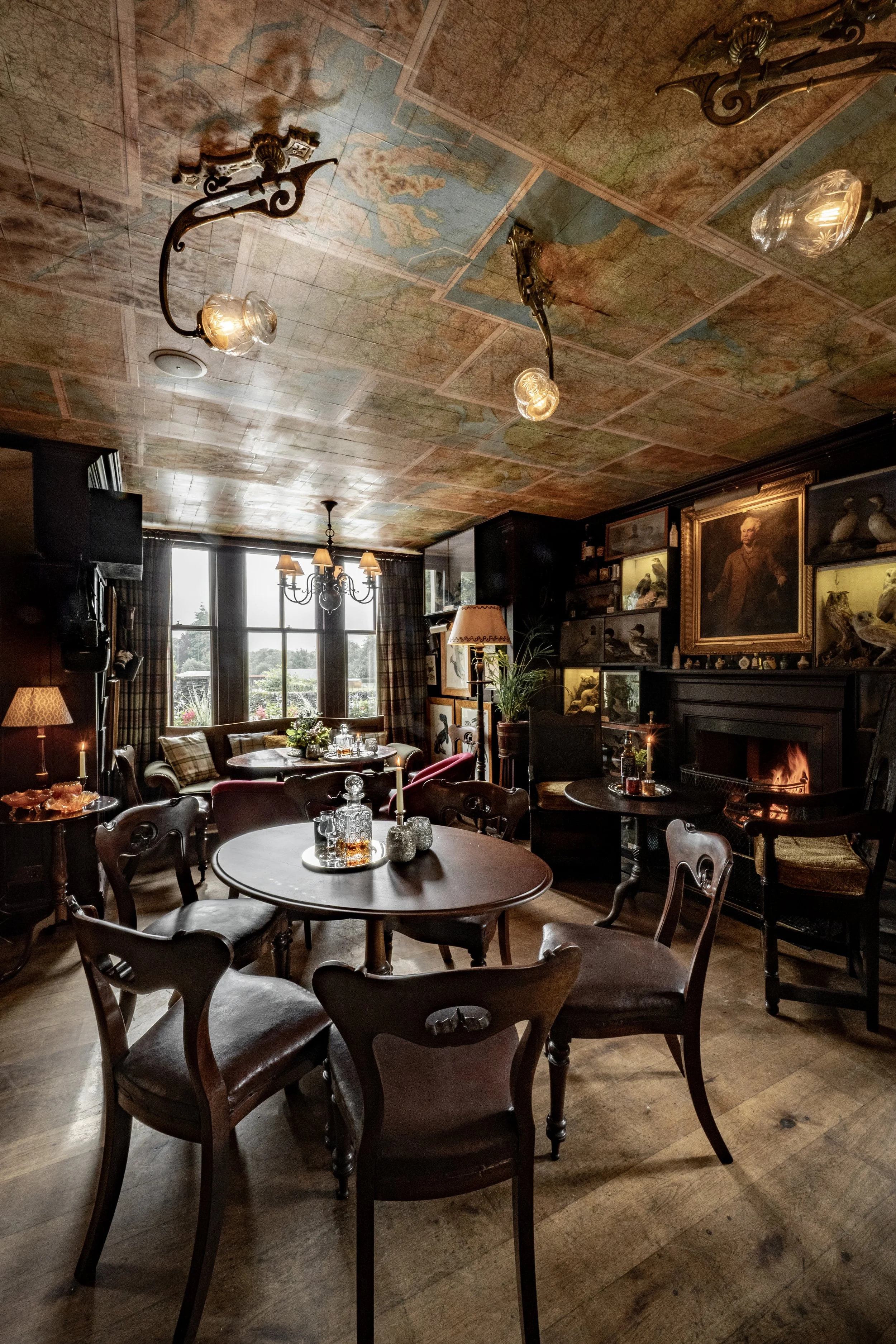 Dramatic room with map ceiling, wooden tables and chairs at the Loch Lomond Arms Hotel, Luss, Scotland