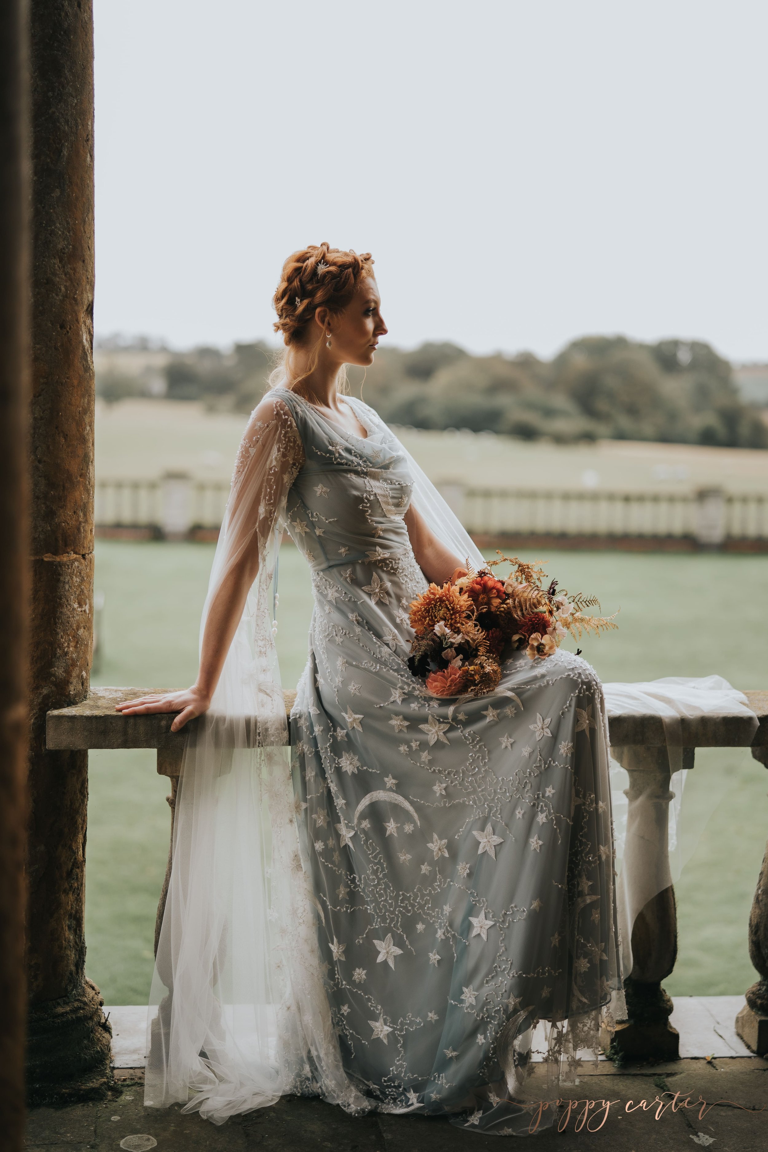 Bride in blue gown sitting on balustrade