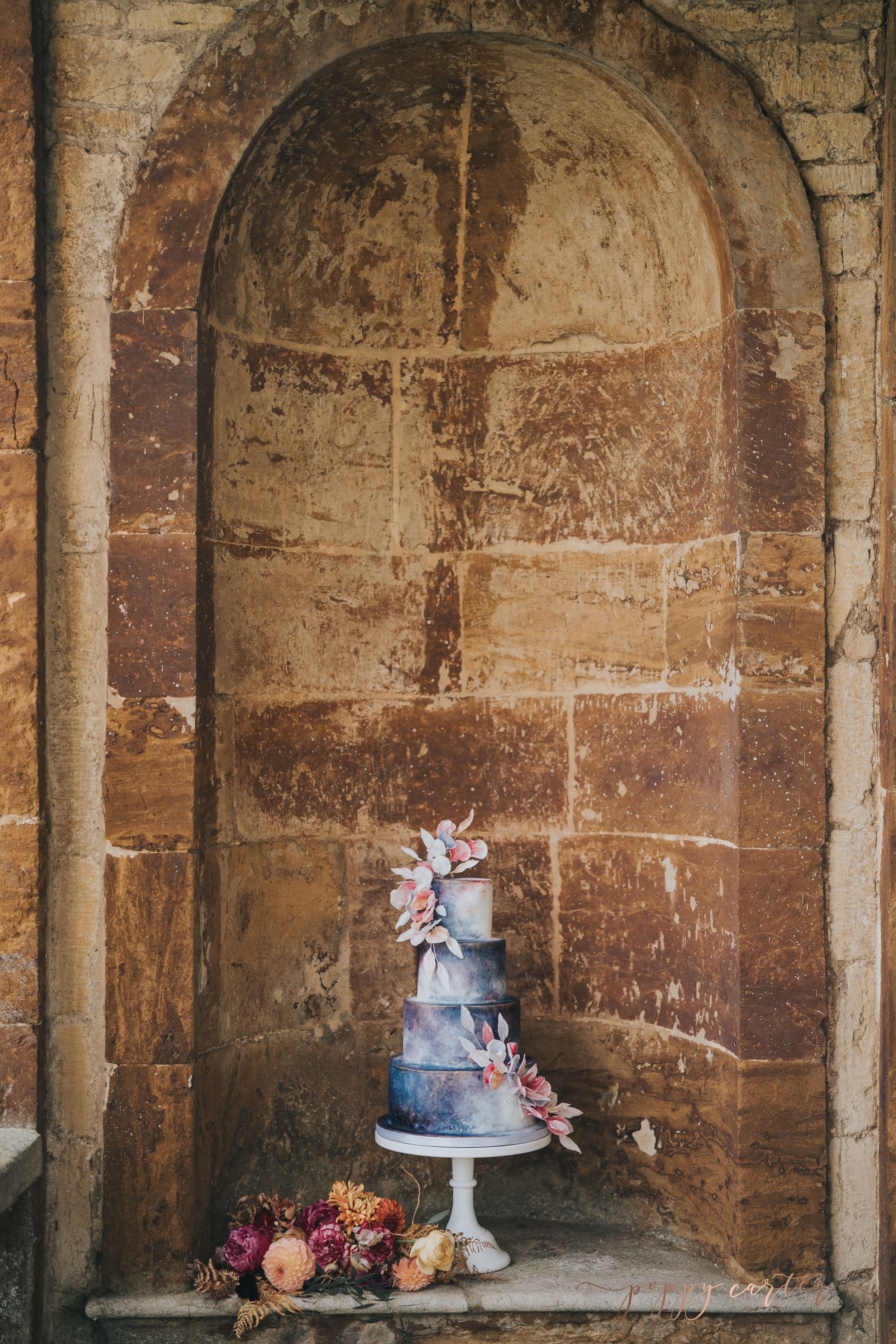 Blue celestial wedding cake in stone alcove