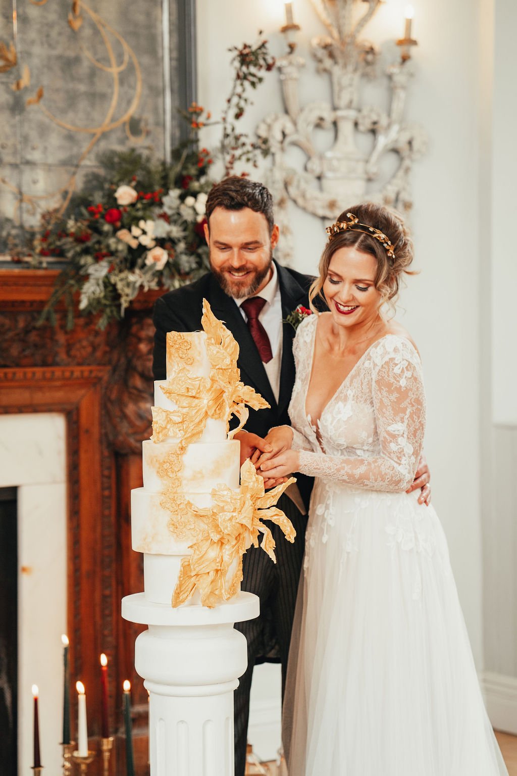 Couple cutting a gold wedding cake