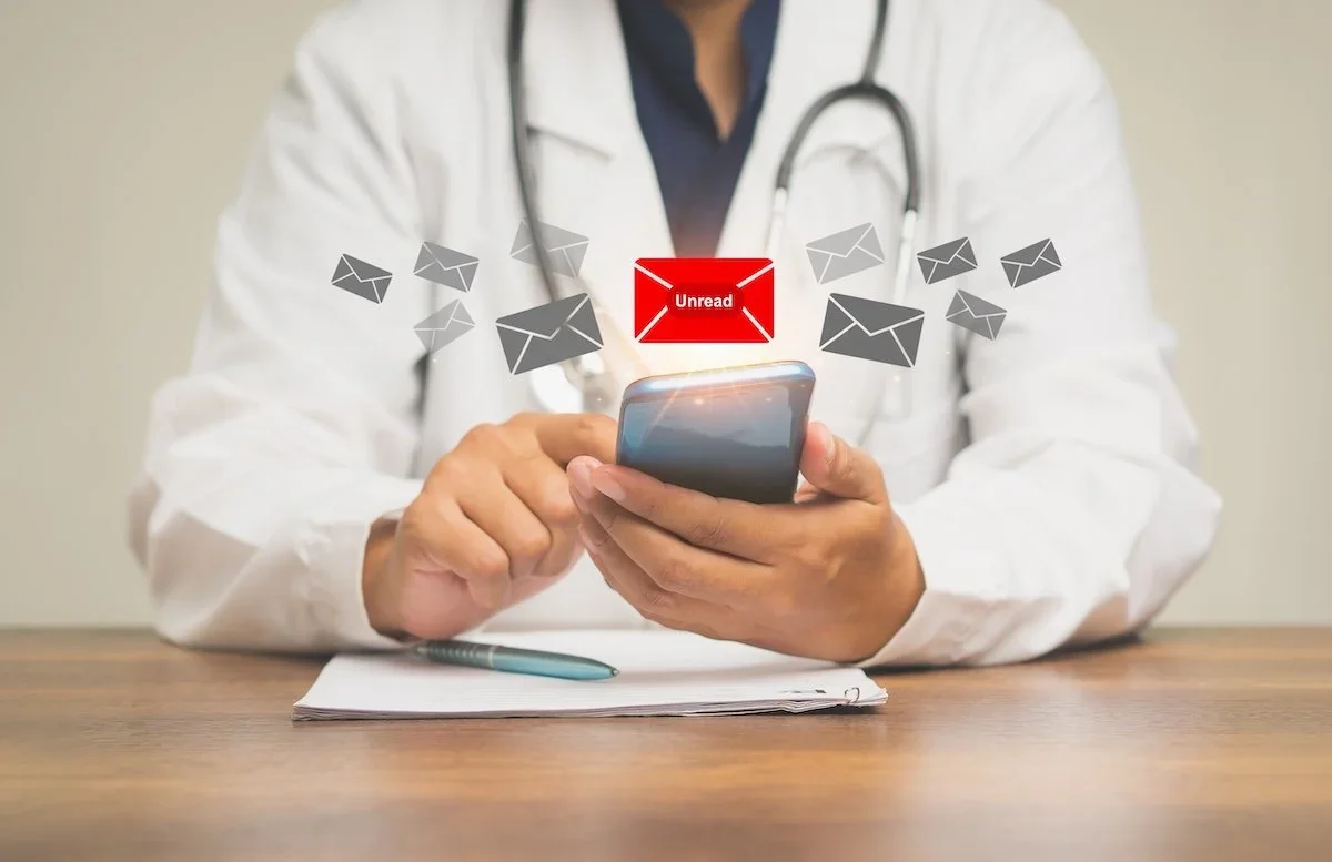 A person wearing a white lab coat and stethoscope using a smartphone, with floating email icons and a red 'Unread' message notification.