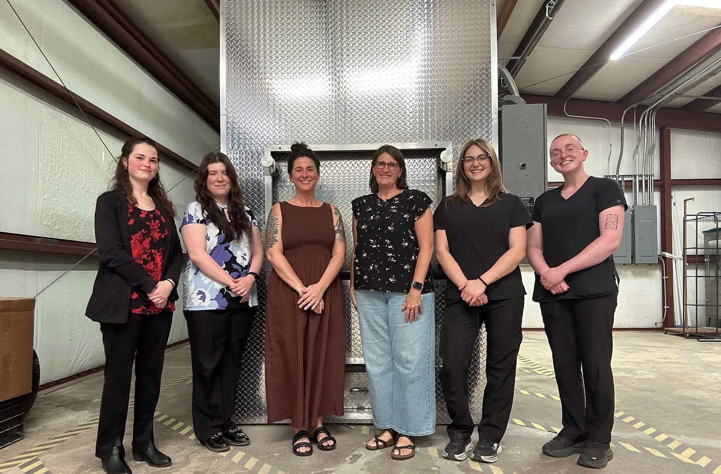 Certified death doulas Jade Adgate and Heather DeWire at Crawford Funeral Home with funeral directors touring cremation facility.