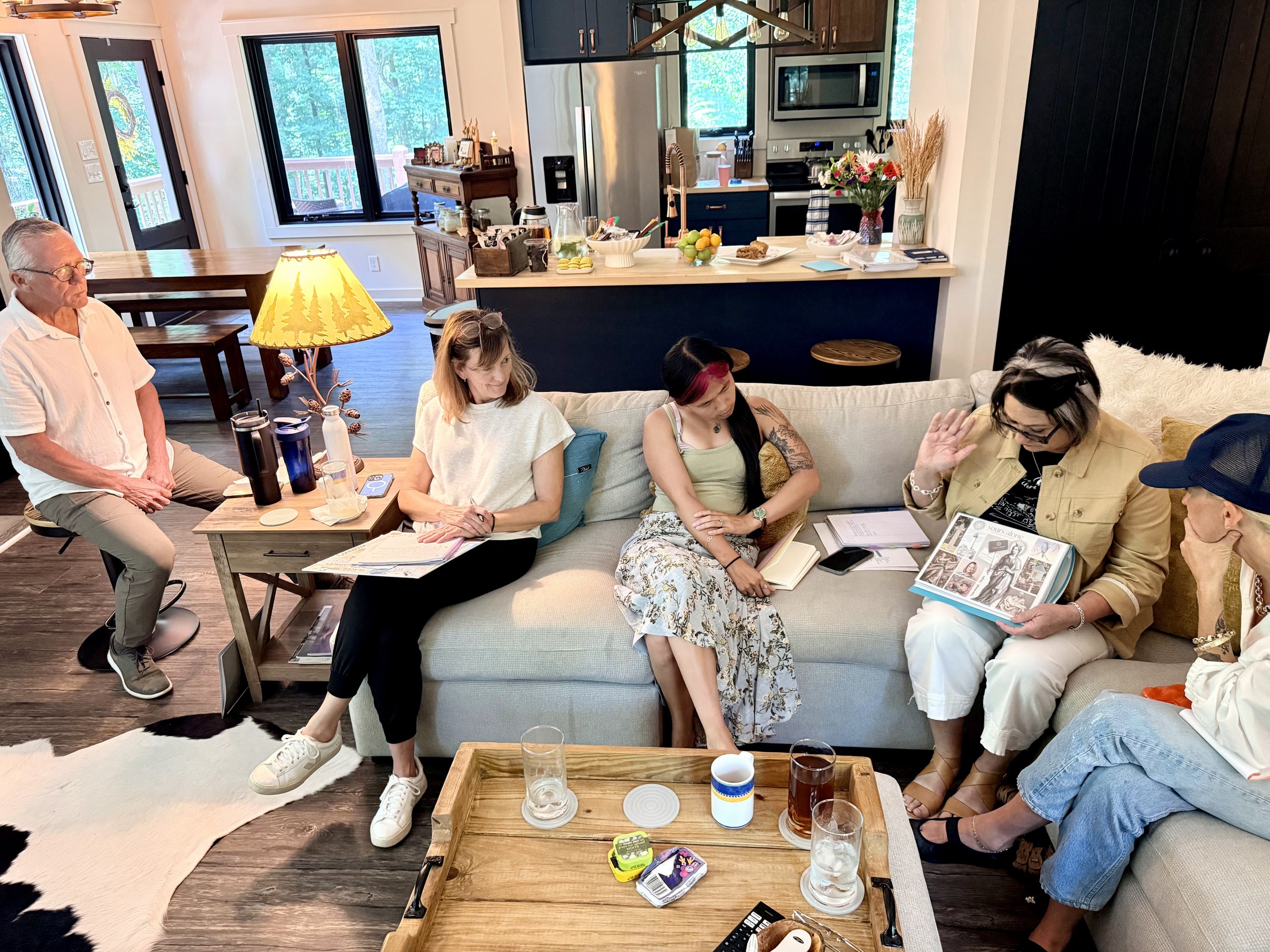 Advanced death doula training cohort members listening to a peer present her death doula business plan during an in-person retreat focused on sustainable practice development, community learning, and end-of-life care.