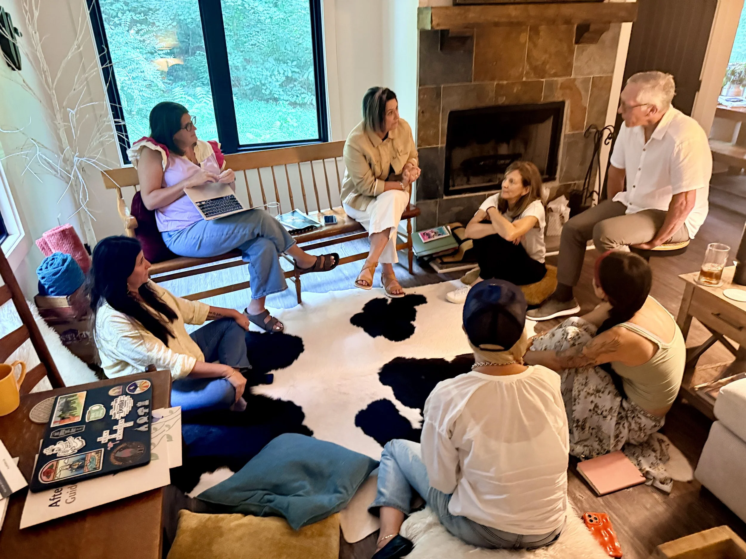 Advanced death doula training cohort seated together in community, listening to a member share personal experiences with death and grief, creating belonging through shared reflection and end-of-life care education.