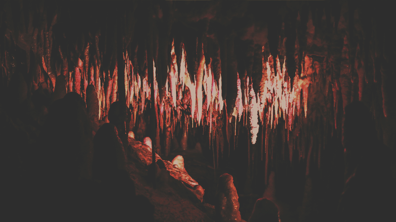Jagged stalagmites evoking the sharp, intense nature of grief, representing trauma-informed and dignity-centered care for death doulas.
