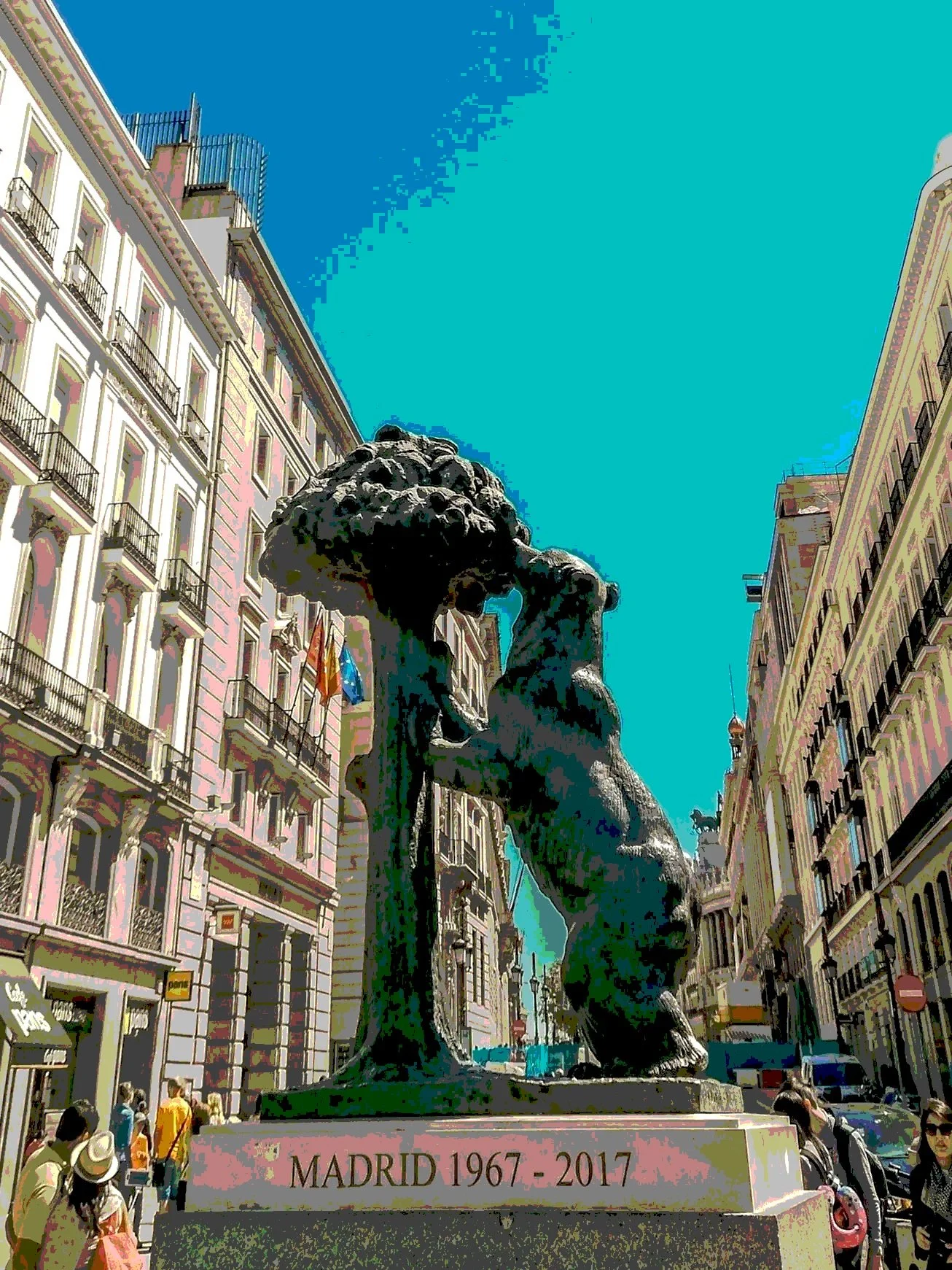 Estatua de un oso en una plaza de la ciudad, rodeada de edificios históricos, conmemorando los 50 años de Madrid (1967-2017), bajo un cielo azul brillante, en la Puerta del Sol.
